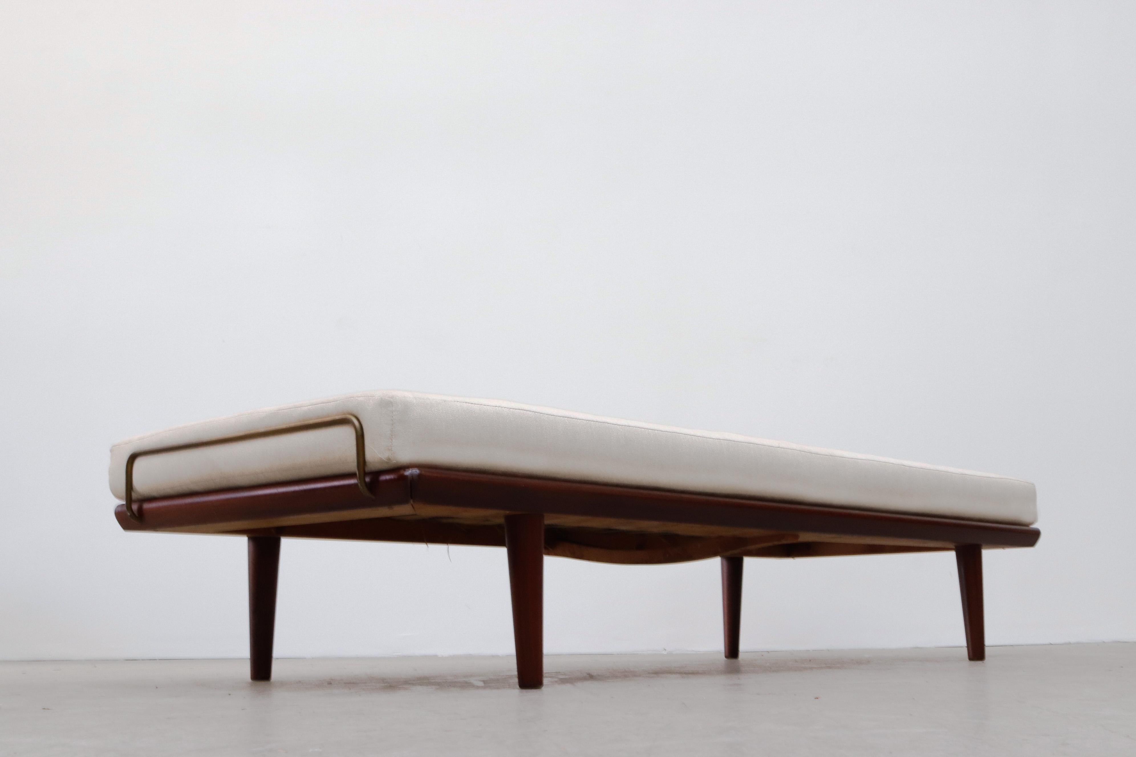 Mid-century Hans Wegner daybed with teak frame, tapered legs and brass end rail accents. In original condition with visible wear and patina consistent with age and use.