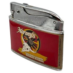 Encendedor de bolsillo de esmalte rojo "Harveys Casino Wagon Wheel" de Vulcan de mediados de siglo