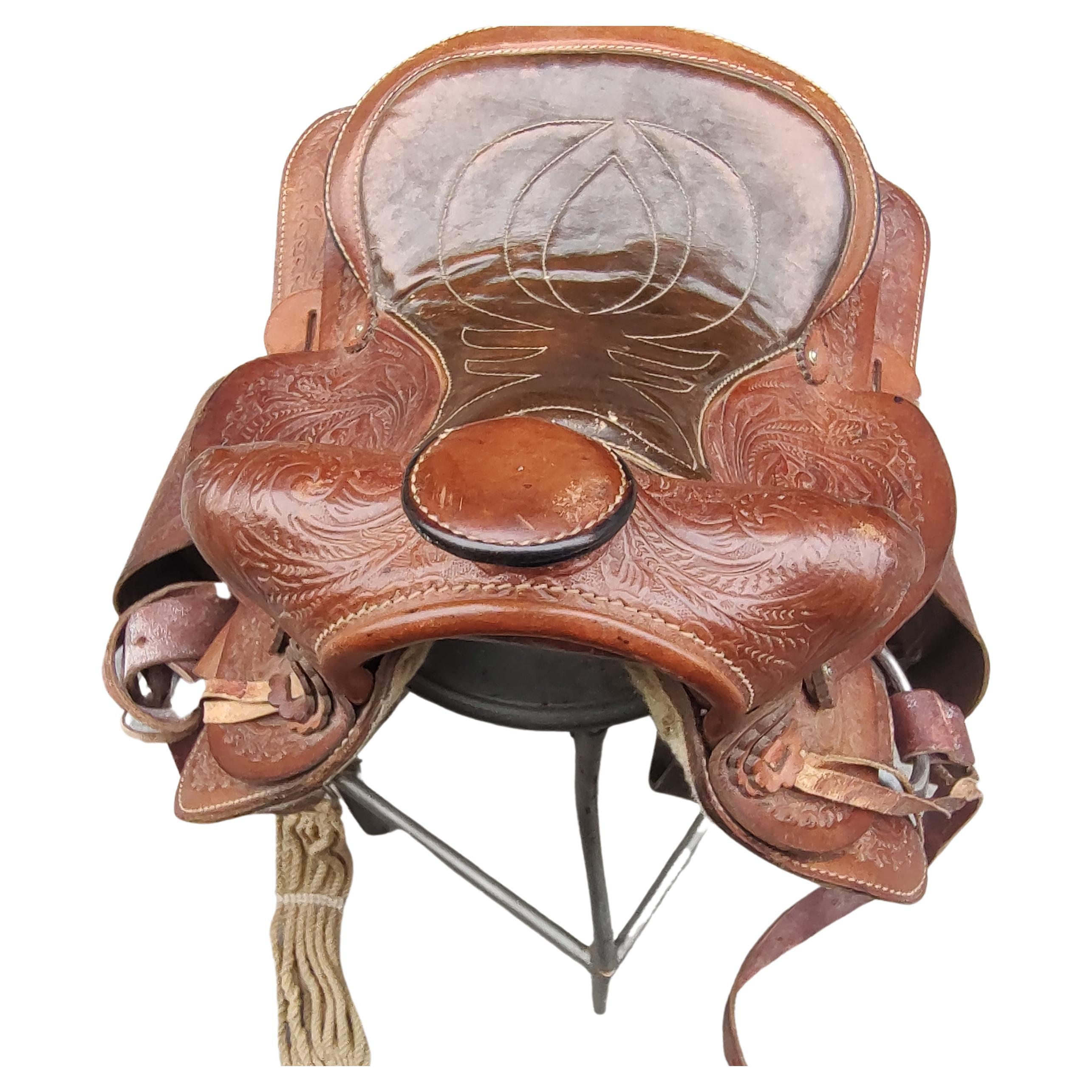 Sella da equitazione western in pelle ben lavorata e goffrata. Forse una taglia junior. In eccellenti condizioni vintage con un'usura minima. 