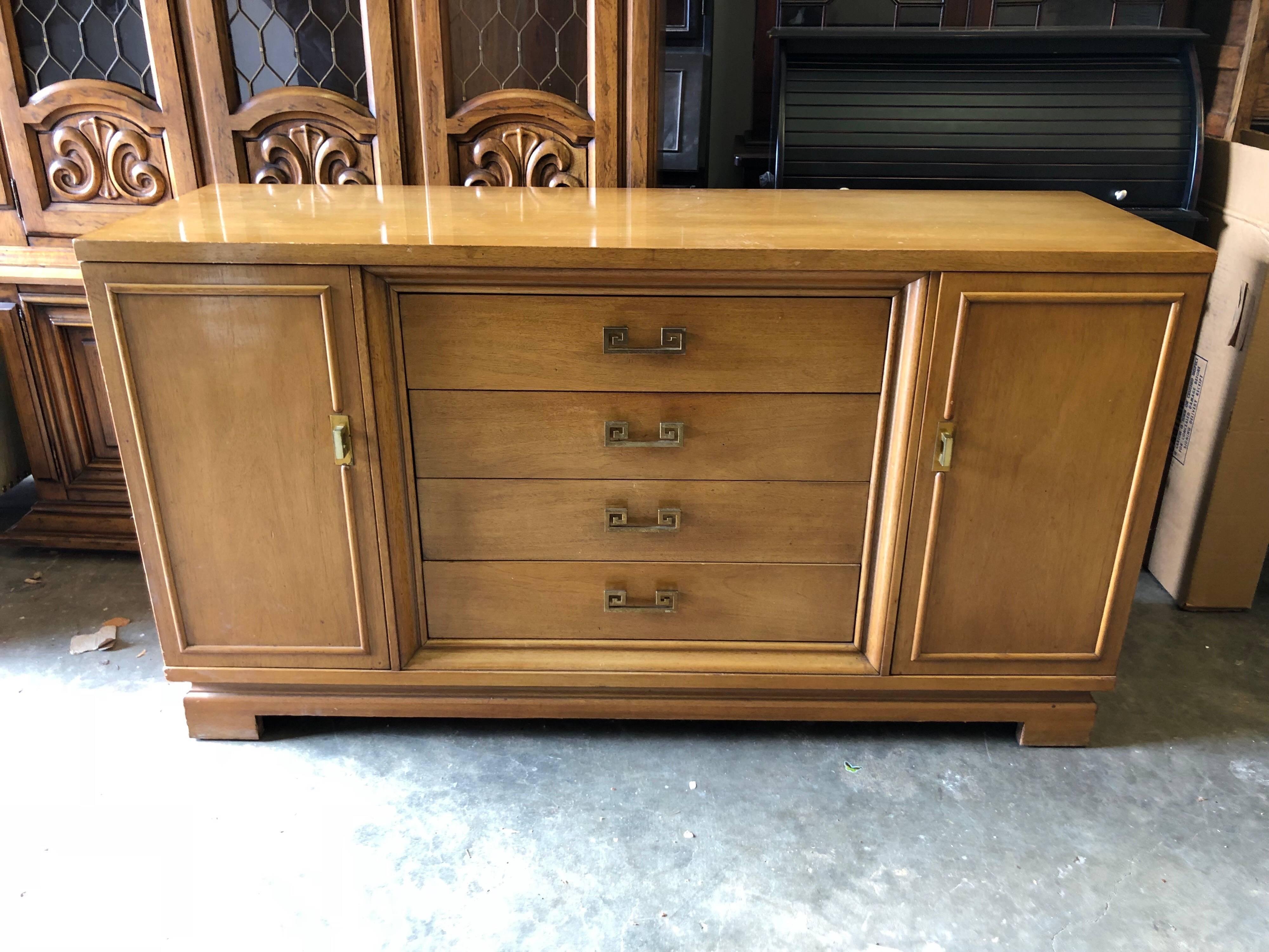 Mid Century Bernhardt credenza or dresser with Greek key handles. Sleek and simple lines make up this beauty. This piece has four drawers and two cabinets doors with shelves allowing ample storage. Great in a bedroom, dining room or living room. Can