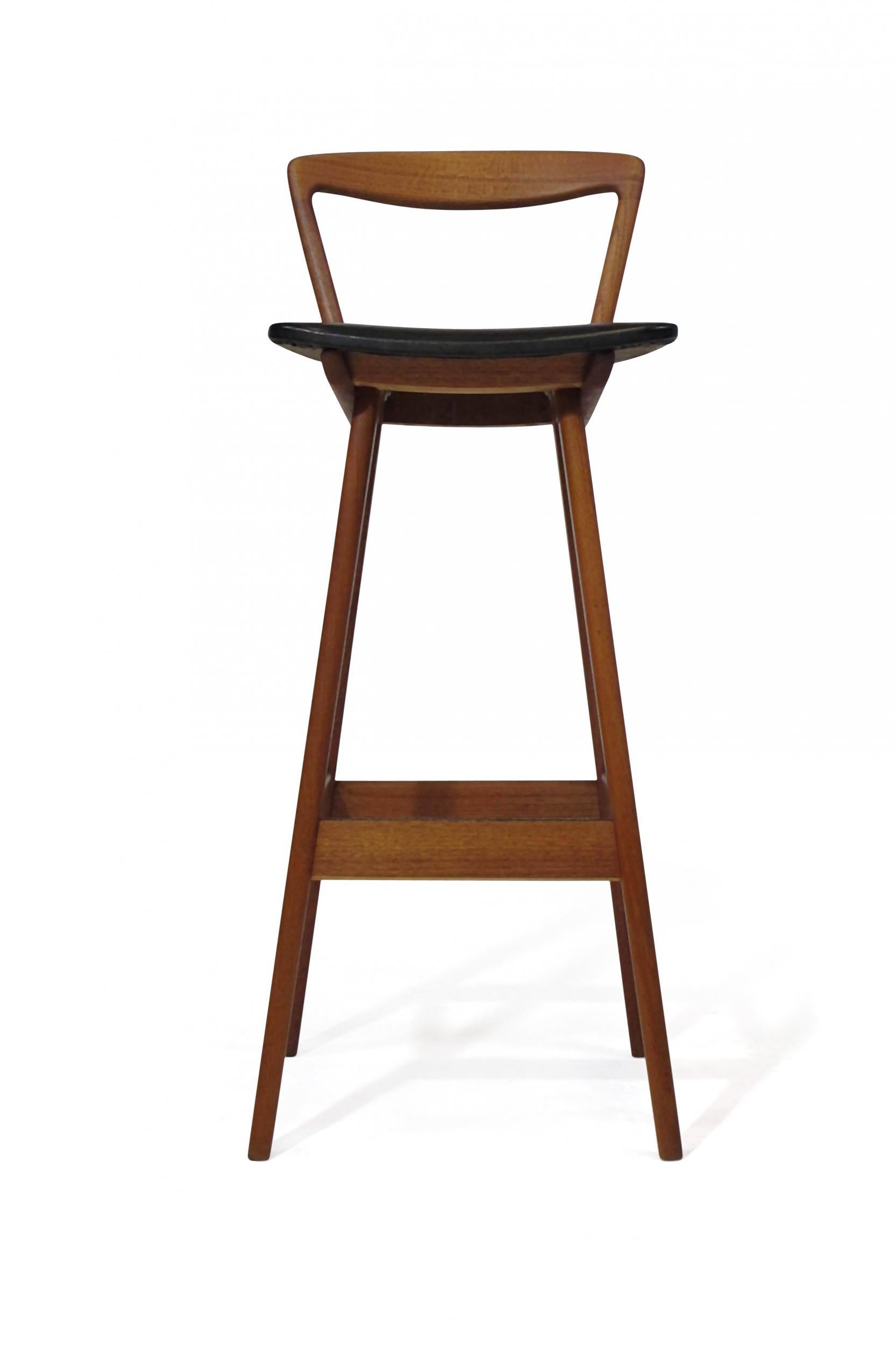 Midcentury teak bar stools designed by Henry Rosengren Hansen for Brande Mobelfabrik model 43, Denmark. Barstool crafted of solid teak frames, elegantly sculpted backrest with the original black vinyl seat raised on flared legs. Excellent condition
