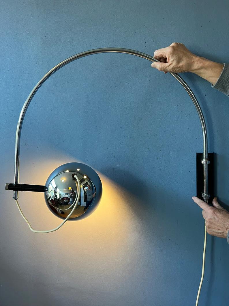Mid century arc wall lamp in chrome by the Dutch brand Herda. The shade can be positioned inside or outside the arc and be turned in any direction. The lamp has a switch build into the cable. The lamp requires an E27 (standard) lightbulb and