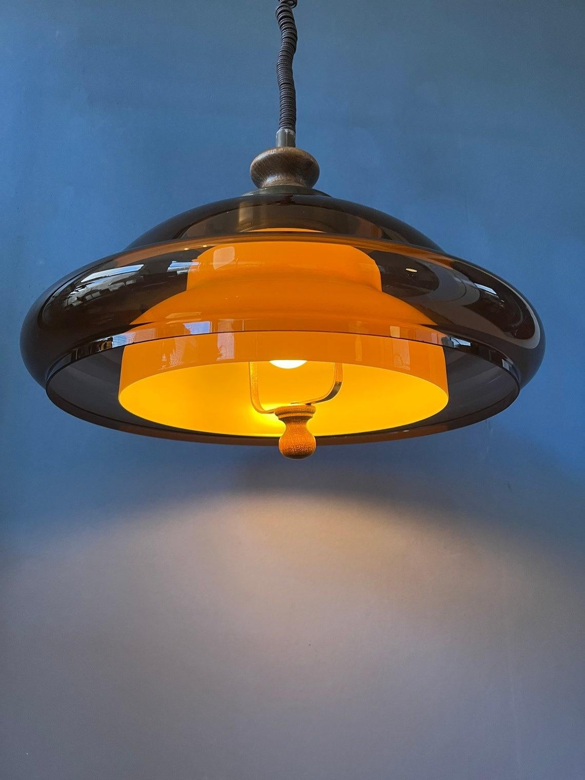 A double shaded space age pendant, presumably by Herda or Dijkstra. The lamp produces a classy light with its transparent outer shade and beige inner shade. The height of the lamp can easily be adjusted with the rise and fall mechanism. The lamp