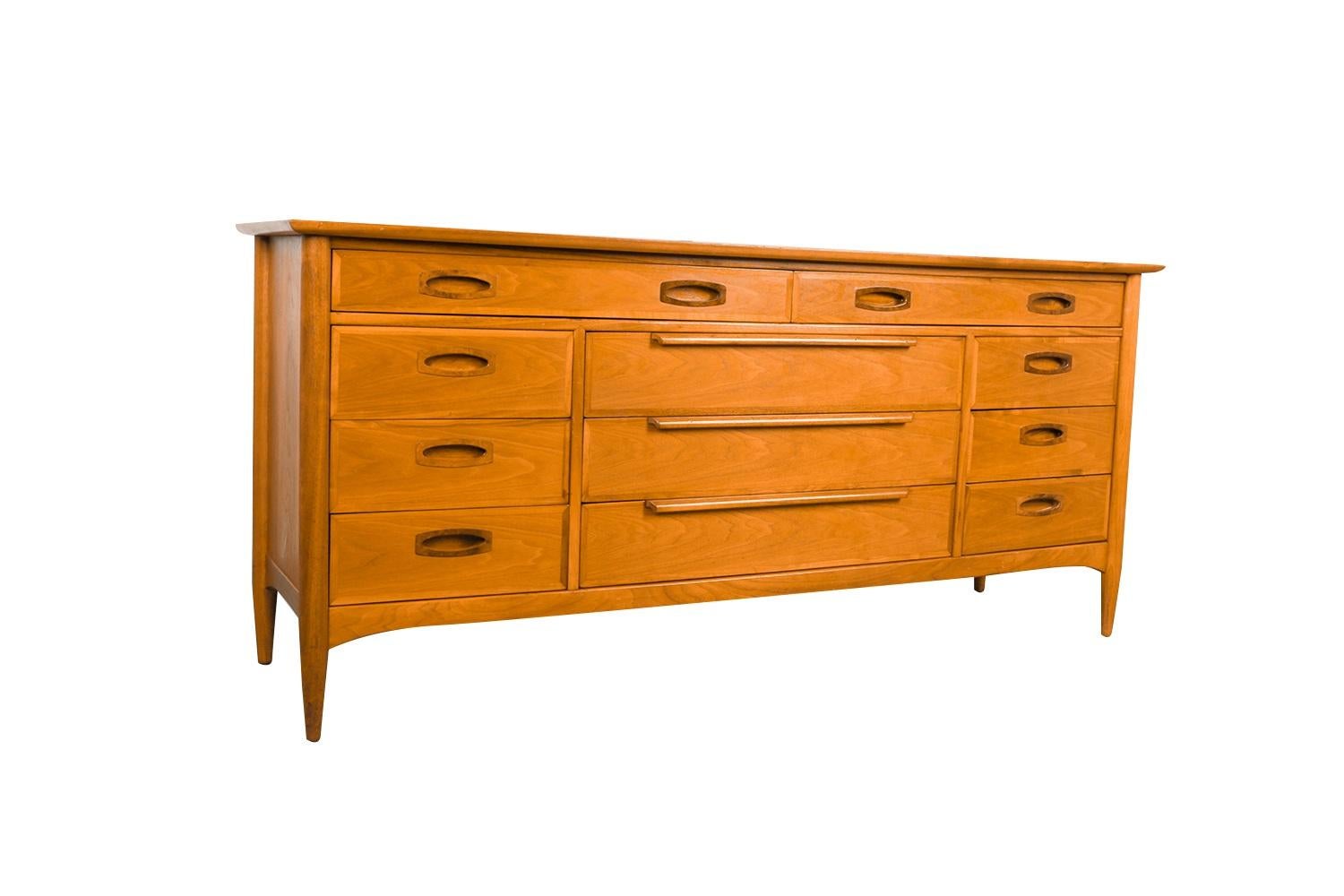 A gorgeous Mid-Century Modern, walnut dresser by Heritage, a leading American furniture designer for over four decades. A beautiful dresser precisely crafted in a rich walnut. Minimalist Danish Modern inspired profile, with exceptional construction
