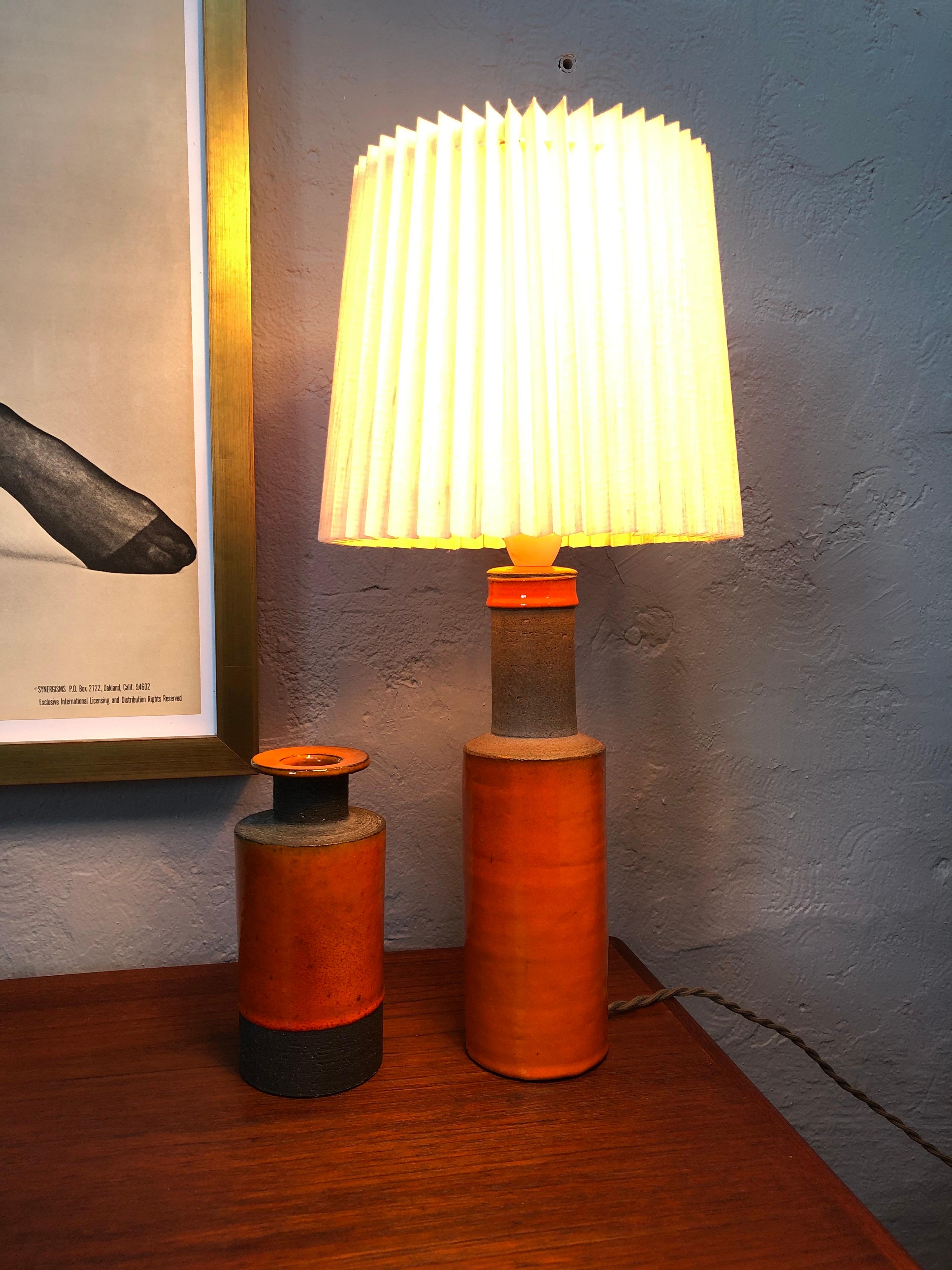 Midcentury Herman A. Kähler HAK pottery lamp from the 1950s in a beautiful orange glaze.
Original label still on the base.
With matching vase.
Rewired and ready to plug in.
Can be fitted with a US or EU plug.
Lampshade not included.
 