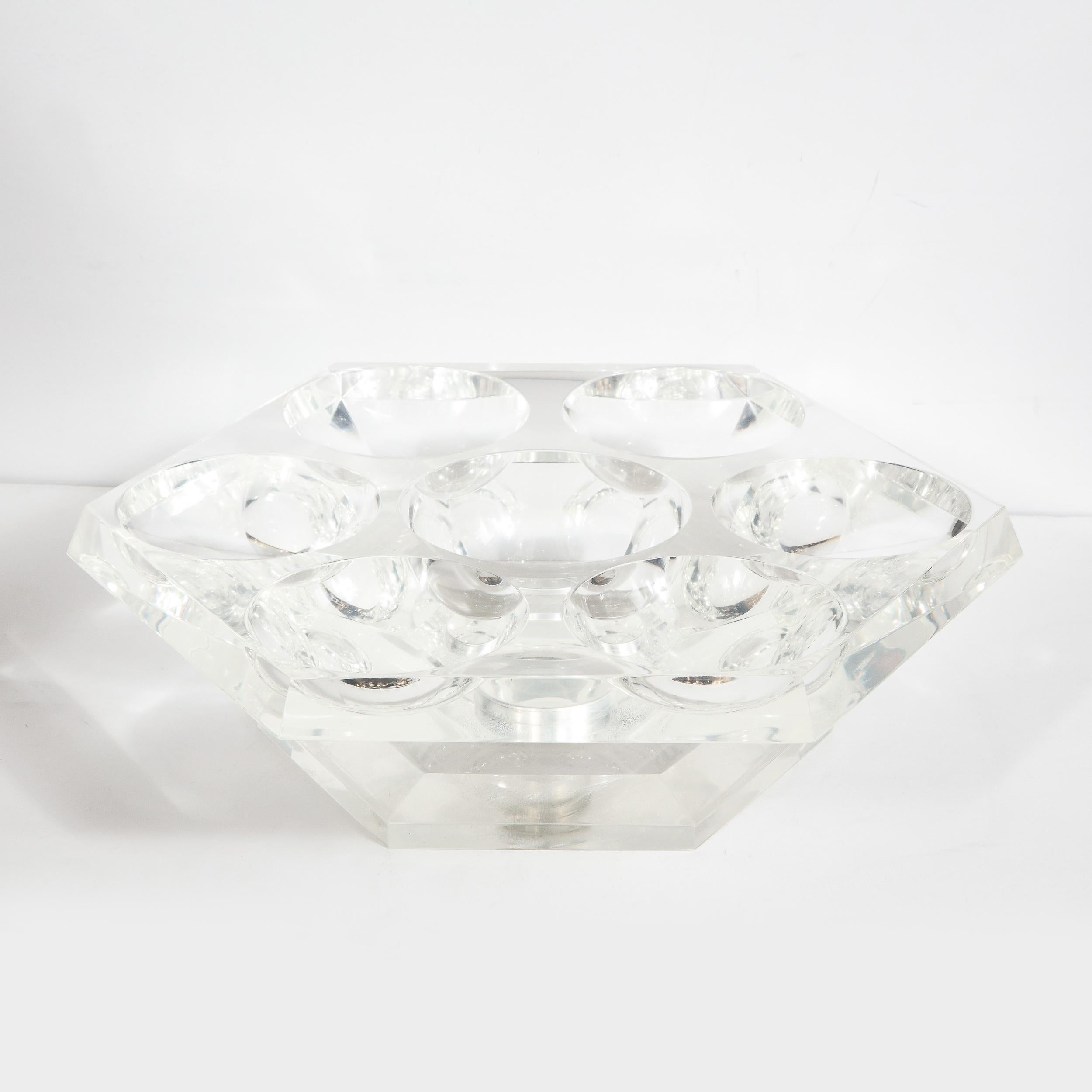This elegant Mid-Century Modern rotating tray was realized in the United States, circa 1970. It features a hexagonal form with a large concave circular indentation in the center surrounded by six smaller circular indentations perfect for serving-