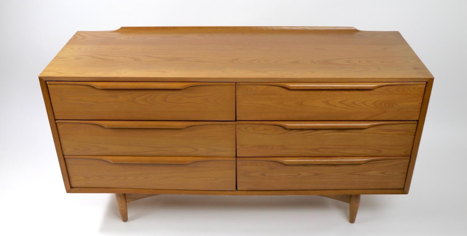 Interesting six drawer dresser  in the Danish Modern style, made by Heywood Wakefield. Nice usable scale, with plenty of storage in deep drawers, very good original condition, showing only light cosmetic wear, normal and consistent with age. Bears