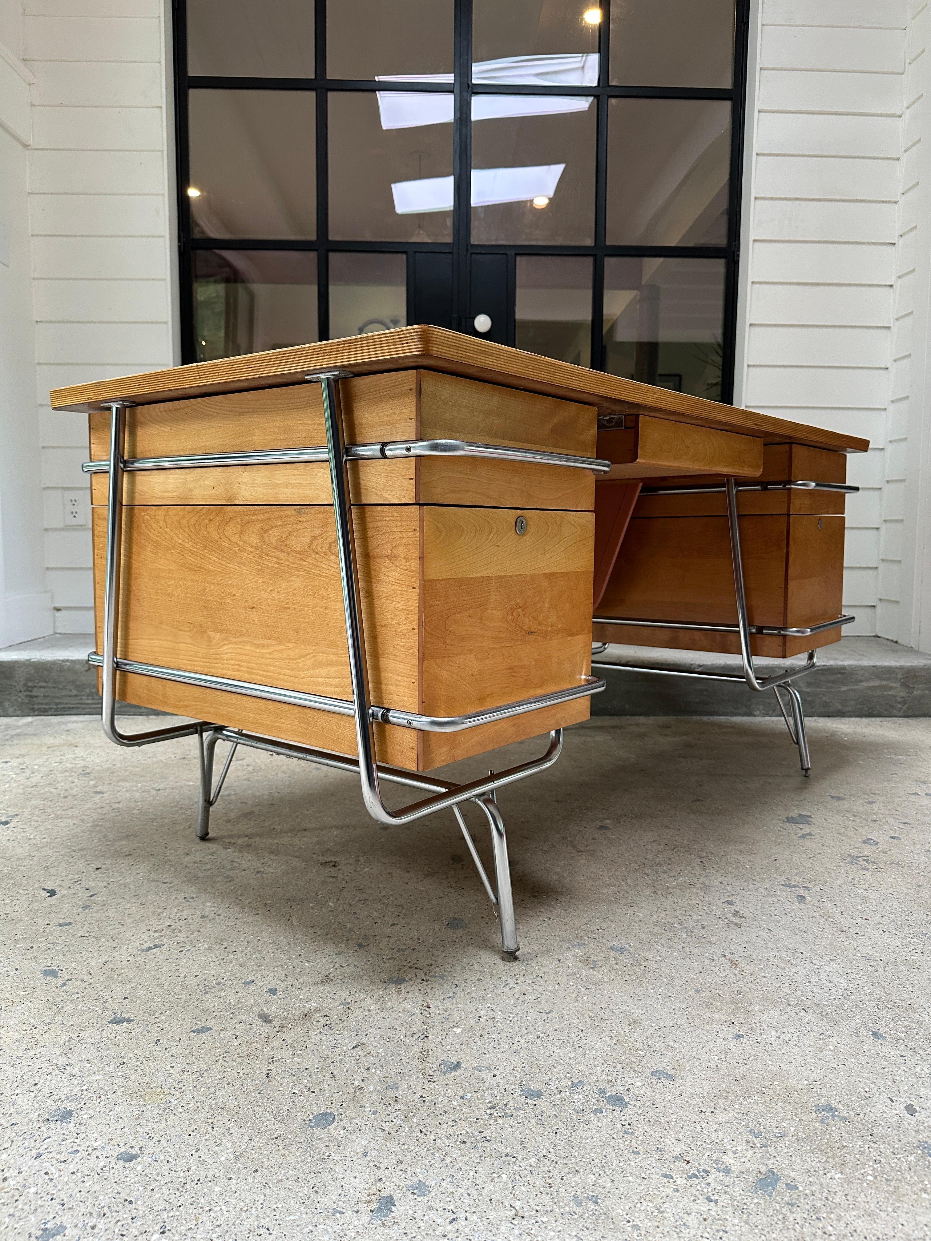 A vintage Mid Century desk designed by Kem Weber and made by Heywood Wakefield. A chrome tubular frame with birch drawers, and peach modesty panel.

59.5”W x 29.5”D x 28 3/4”H