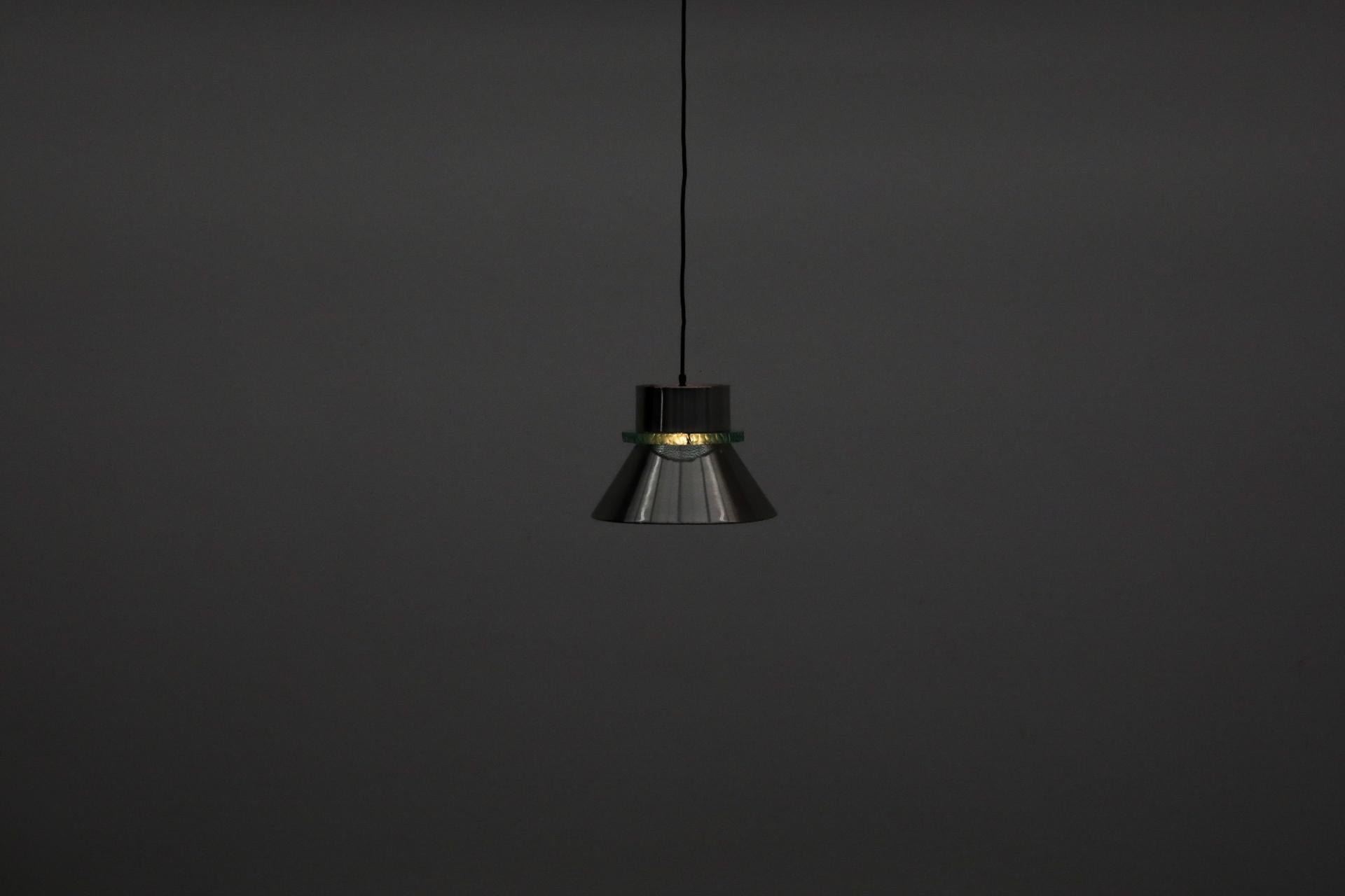 Hiemstra-Pendelleuchte aus der Jahrhundertmitte mit einem dicken Glasring zwischen dem oberen und dem unteren Kegelschirm aus gedrehtem Aluminium. Im Originalzustand mit sichtbaren Gebrauchsspuren, darunter minimale Dellen und einige Kratzer. Die
