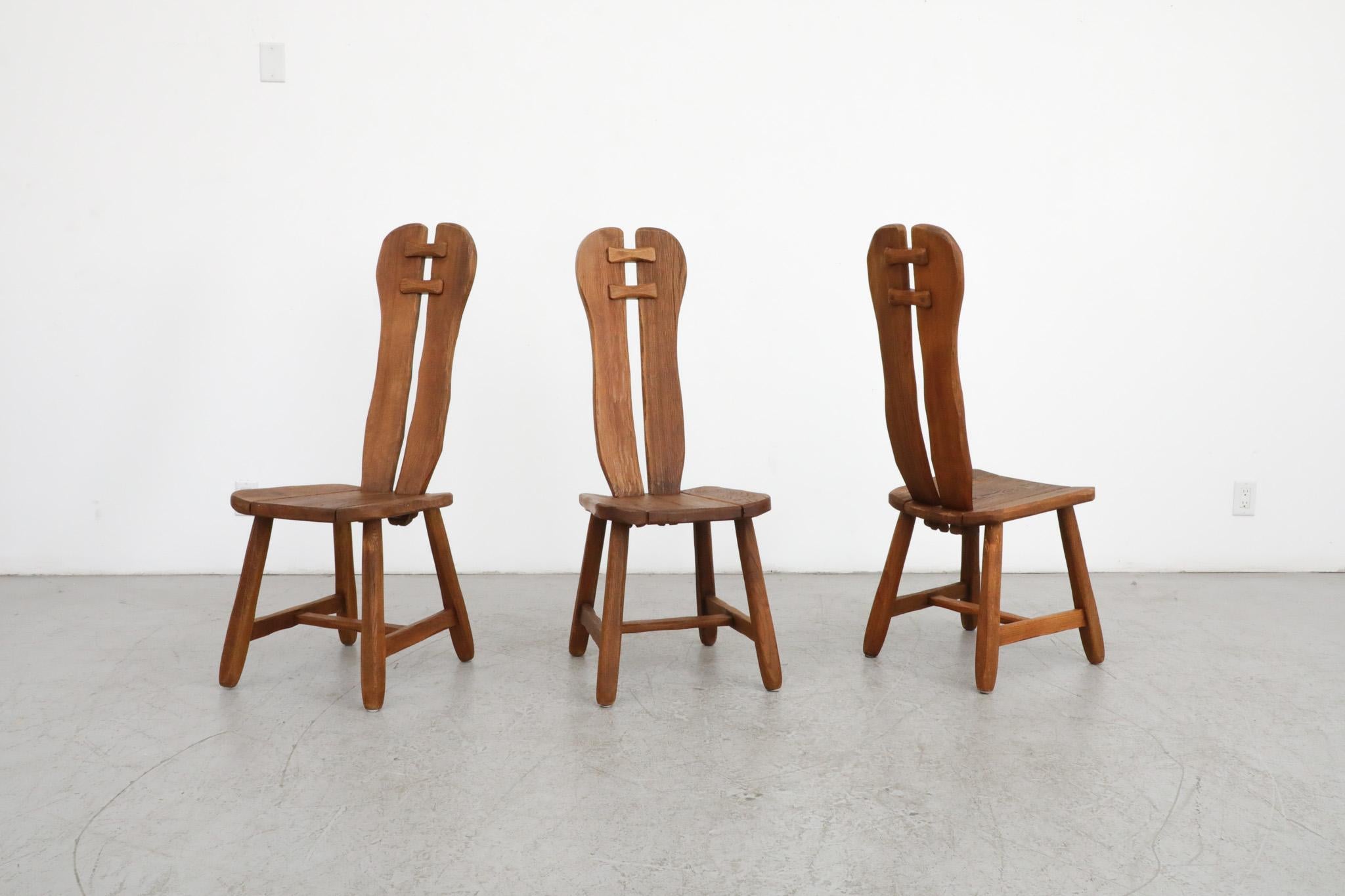 Mid-Century, high back brutalist dining chairs by De Puydt, Belgium. Distinct design from the 1970's, made from rough oak with heavy grain. In original condition with some visible cracking and normal wear and patina for their age. Sold individually.