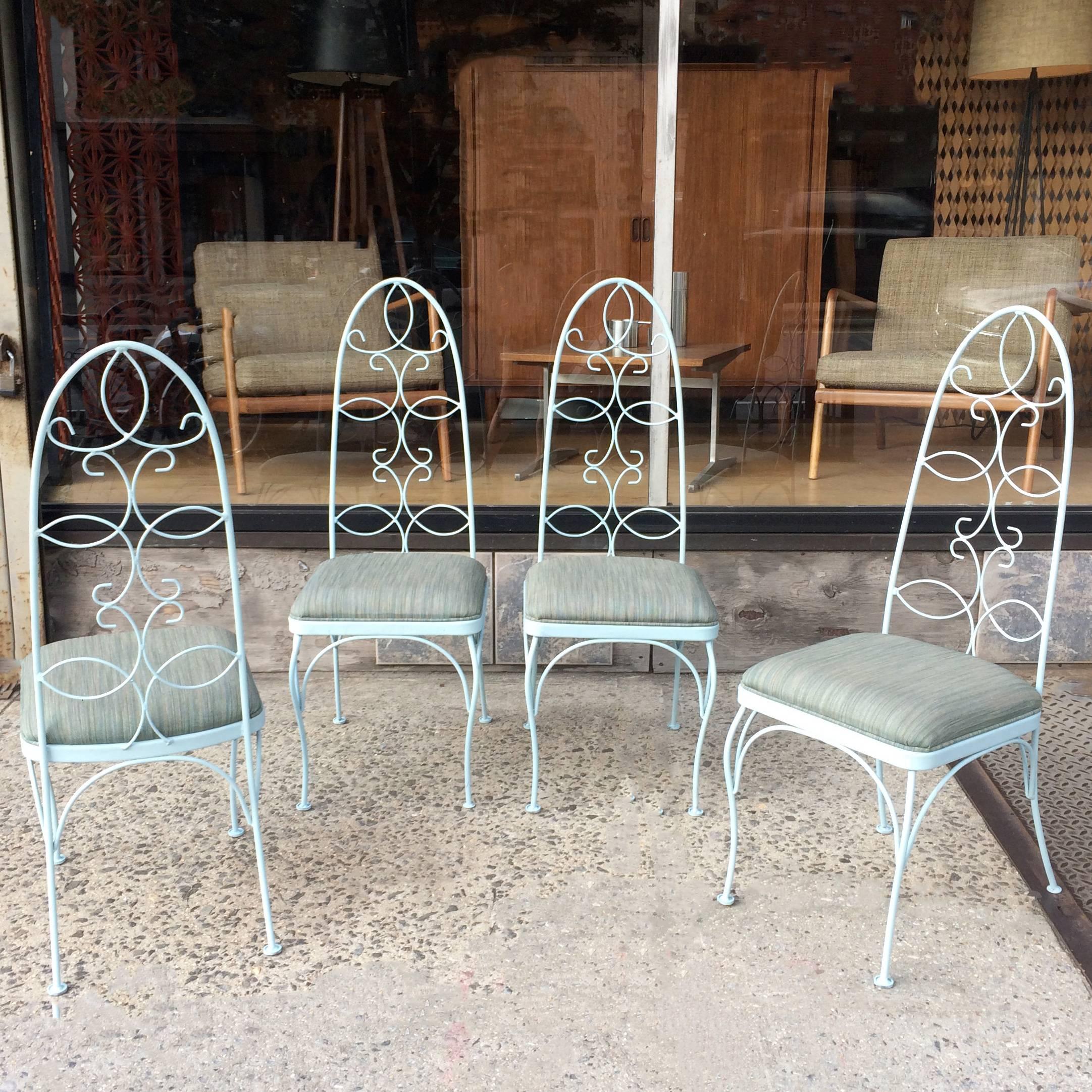 Set of four, mid century, patio, garden, outdoor chairs feature scrolled, wrought iron, high back frames newly painted in light blue and newly upholstered seats in durable outdoor fabric.