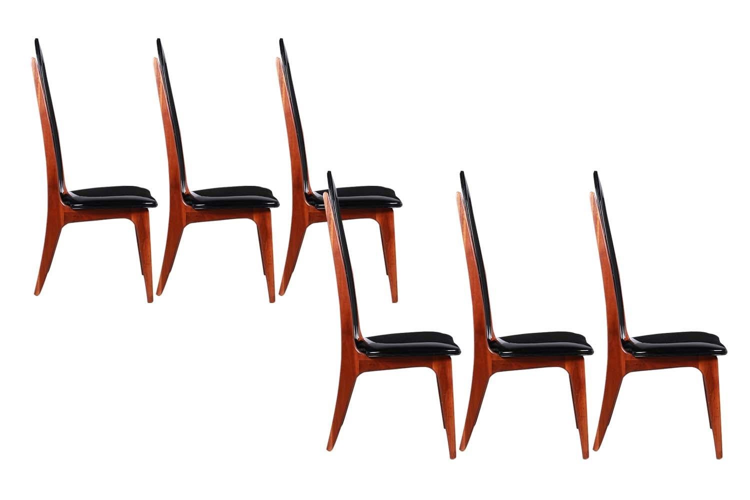 An outstanding set of six mid century dining chairs attributed to Adrian Pearsall. This stunning set of six highback chairs features high arched backs with two sleek walnut rails centered on the back over a walnut frame with splayed legs give these