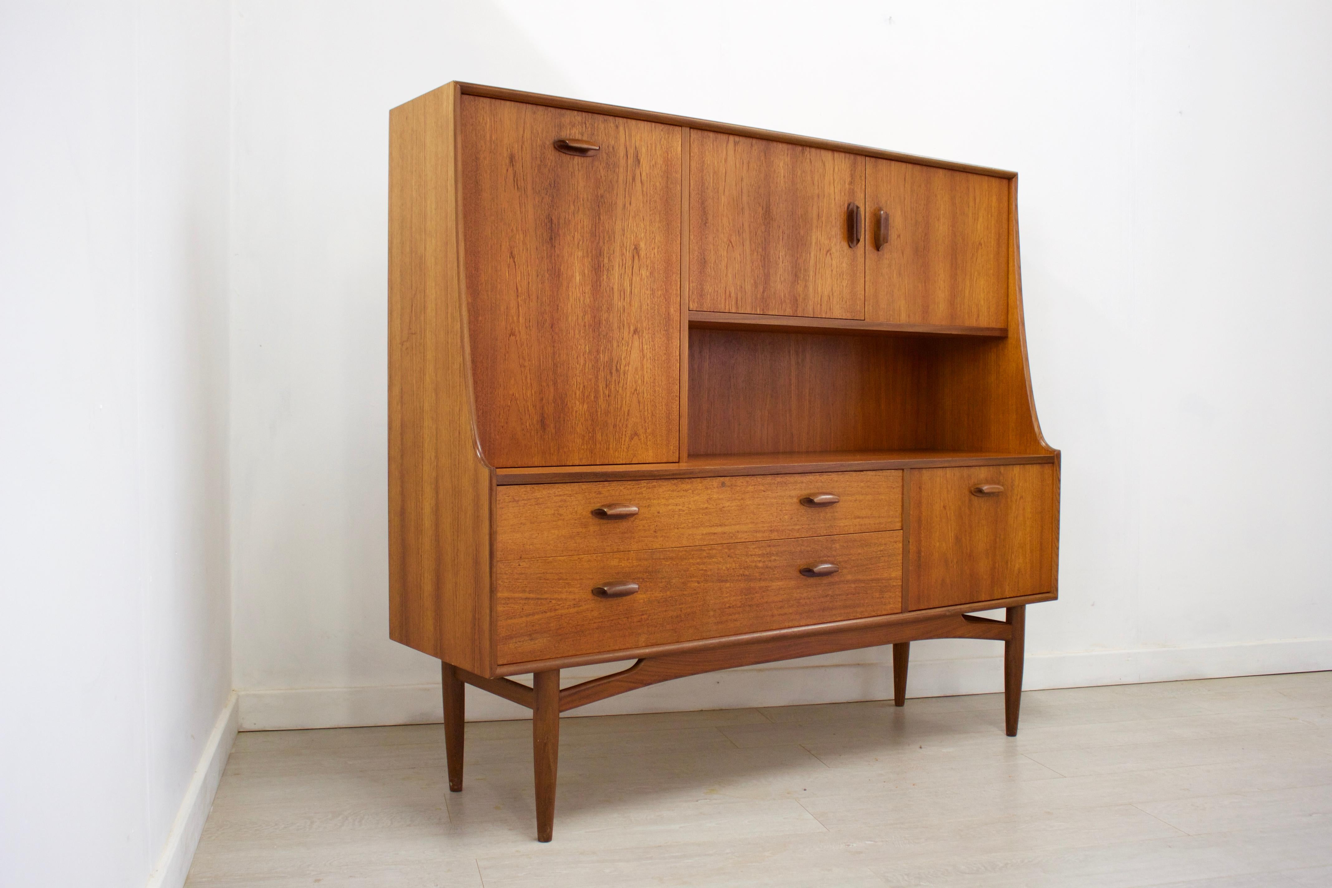 - Mid-Century Modern highboard or sideboard
- Featuring a pull down drinks cabinet
- Manufactured by G Plan in the UK
- Made from teak and teak veneer.
  