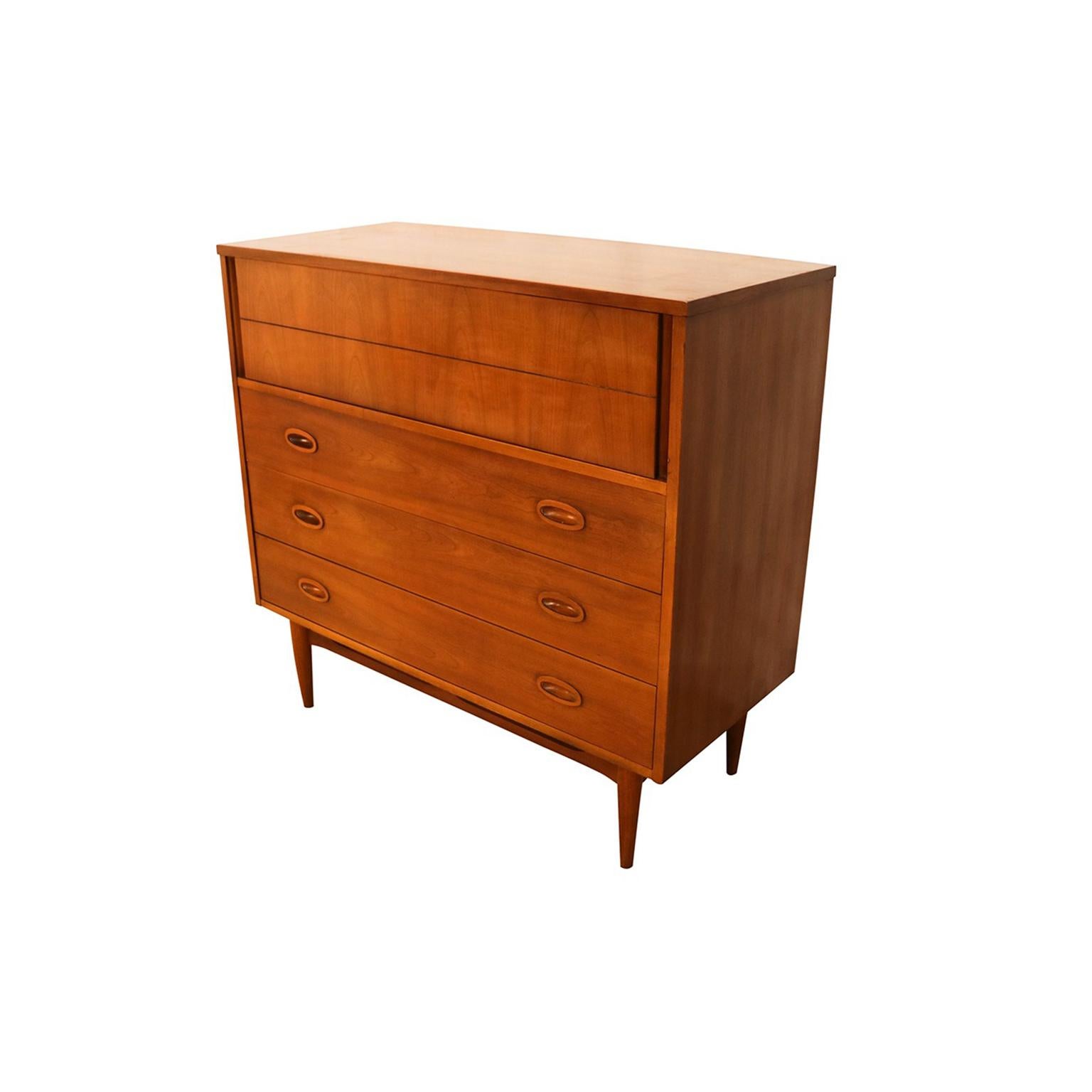An elegant modern highboy tall dresser. This is a beautiful example of midcentury craftsmanship by Dixie Furniture, features four deep drawers for plenty of storage, with manufacturer’s label stamped on the inside of drawer (Dixie). An extremely