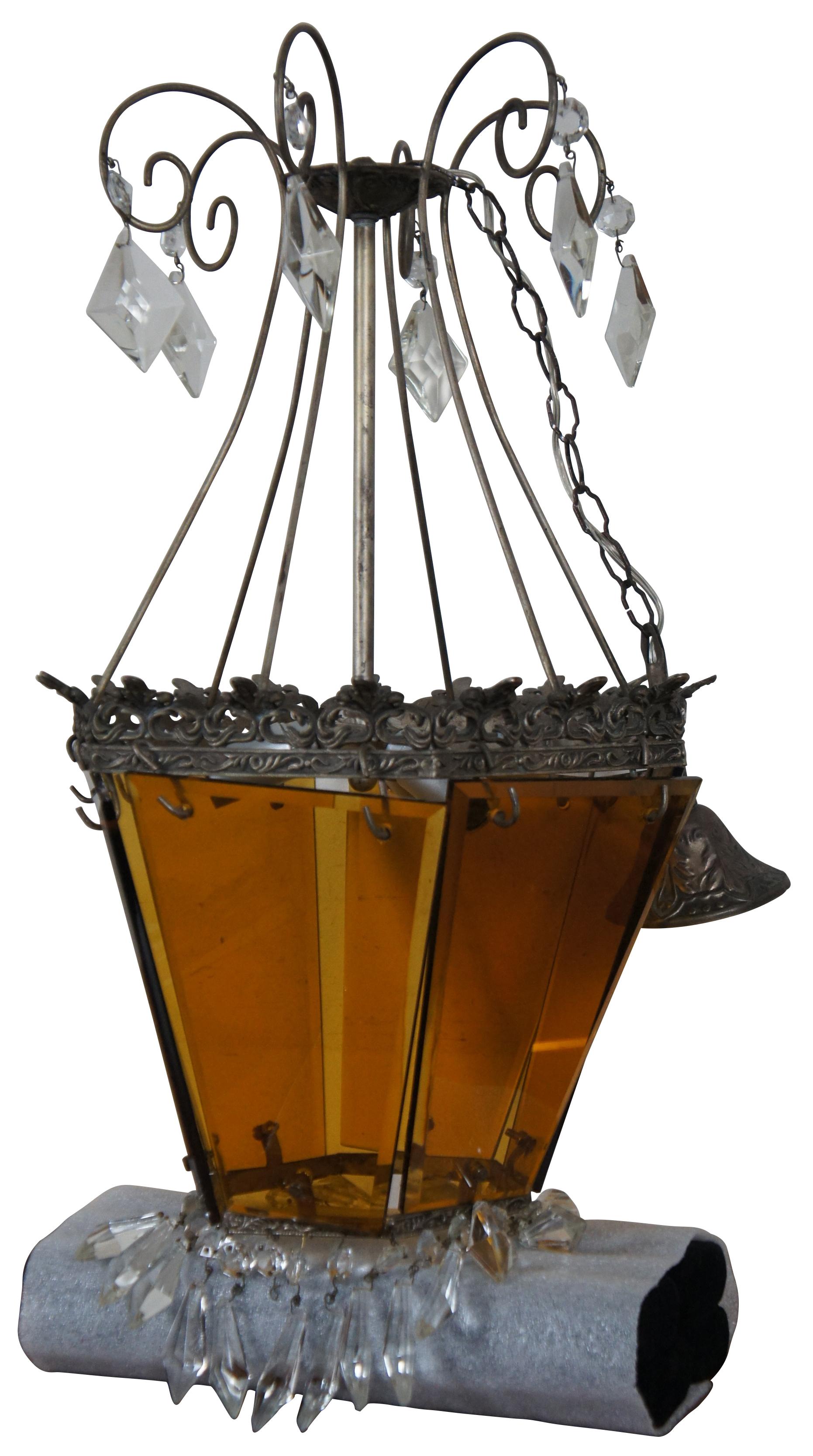 Vintage Hollywood Regency / Victorian / Gothic or Spanish Revival style pendant light or hanging lantern with scrolled metal accents, amber glass panels, and drop crystal borders.

Measures: 12.5” x 23” / Chain length – 16” (Diameter x