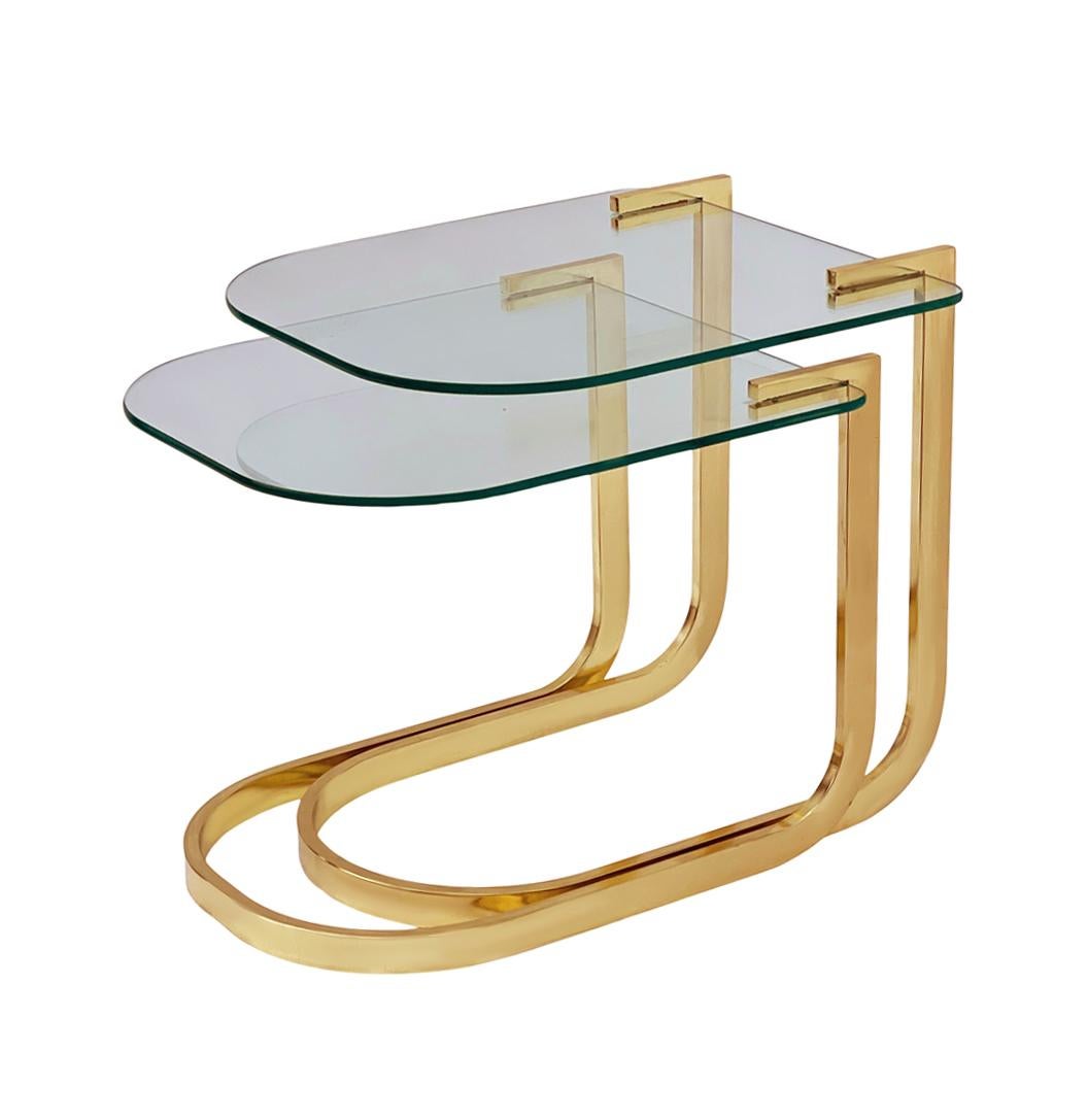 A transitional modern set of nesting end tables or side tables. These feature bright brass frames with thick clear glass. Very good condition.