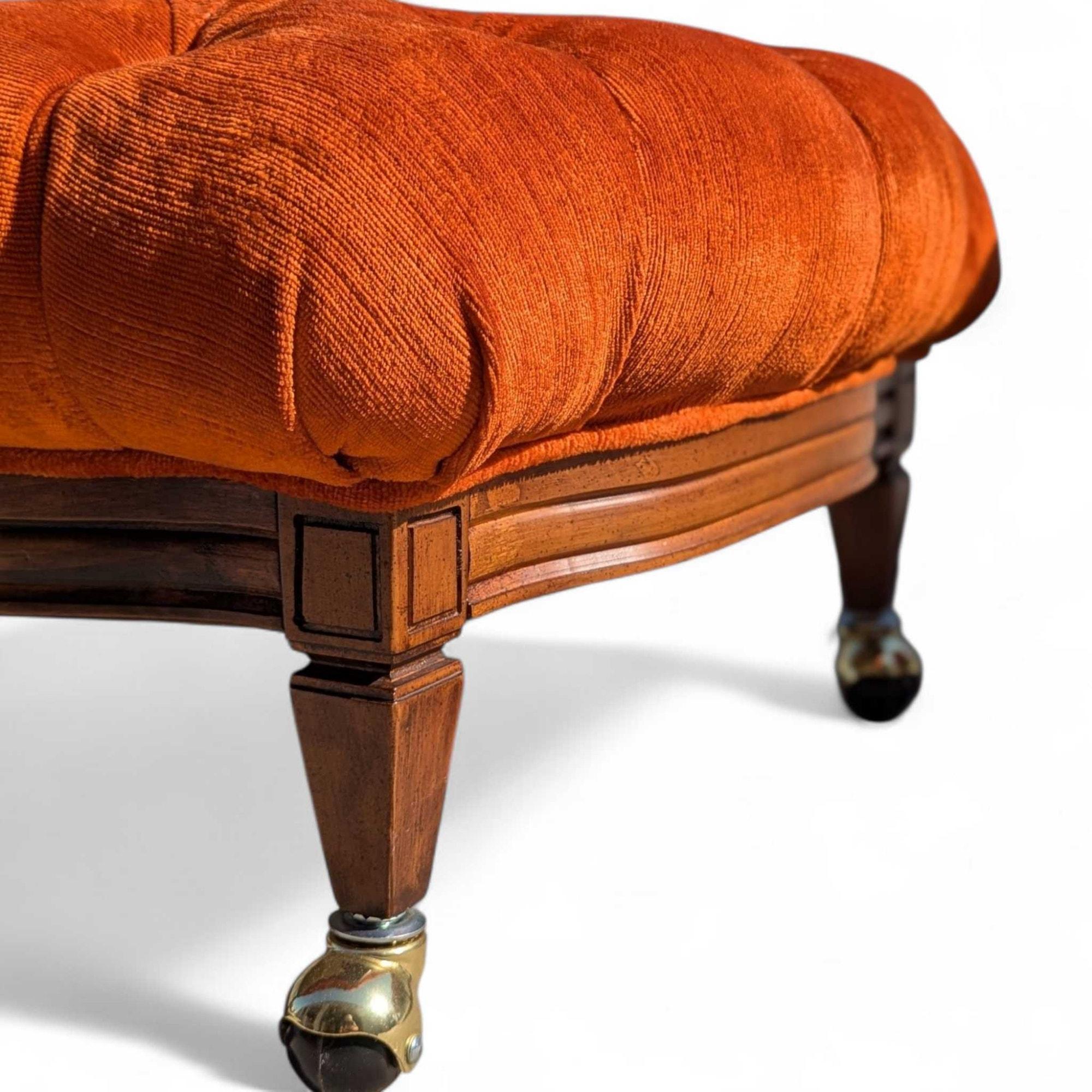 Ein elegantes Paar Ottomane aus der Mitte des Jahrhunderts mit leuchtend orangefarbenem Kordbezug, tiefem Tufting und eleganten Holzbeinen mit Rollen aus Messing und Holz.

Design-Einflüsse - Mid-Century Modern, Hollywood Regency. Diese Ottomane