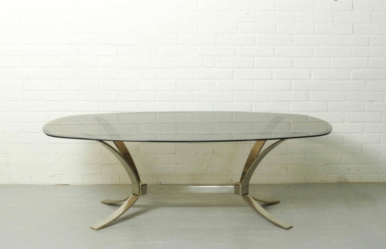 Amazing vintage midcentury metal (with a hint of goldcolor) base coffee table from the 1960s or 1970s with an oval smoked glass top attributed to Roger Sprunger for Dunbar. In good vintage condition. 

Measurements: H 47 x W 80 x D 140 cm.
    