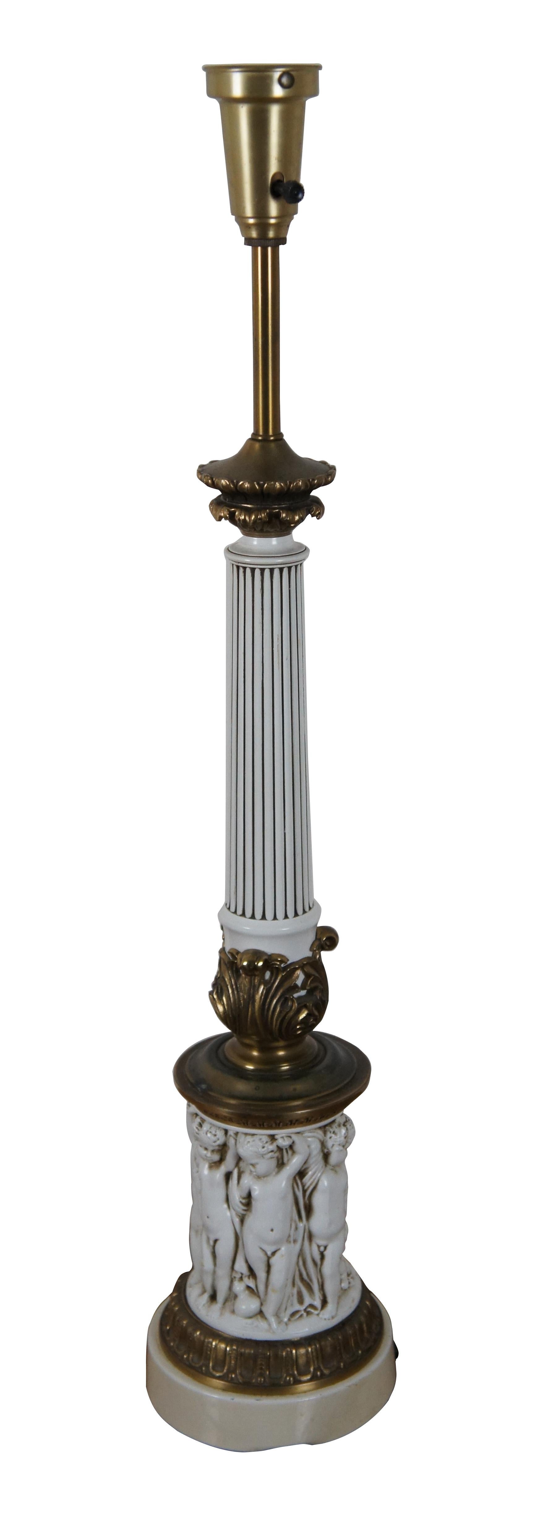 Mid 20th century Hollywood Regency style torchiere style table lamp in brass and white painted resin, in the shape of a Corinthian column with a particularly ornate base featuring a frieze of Putti / cherubs. No shade.