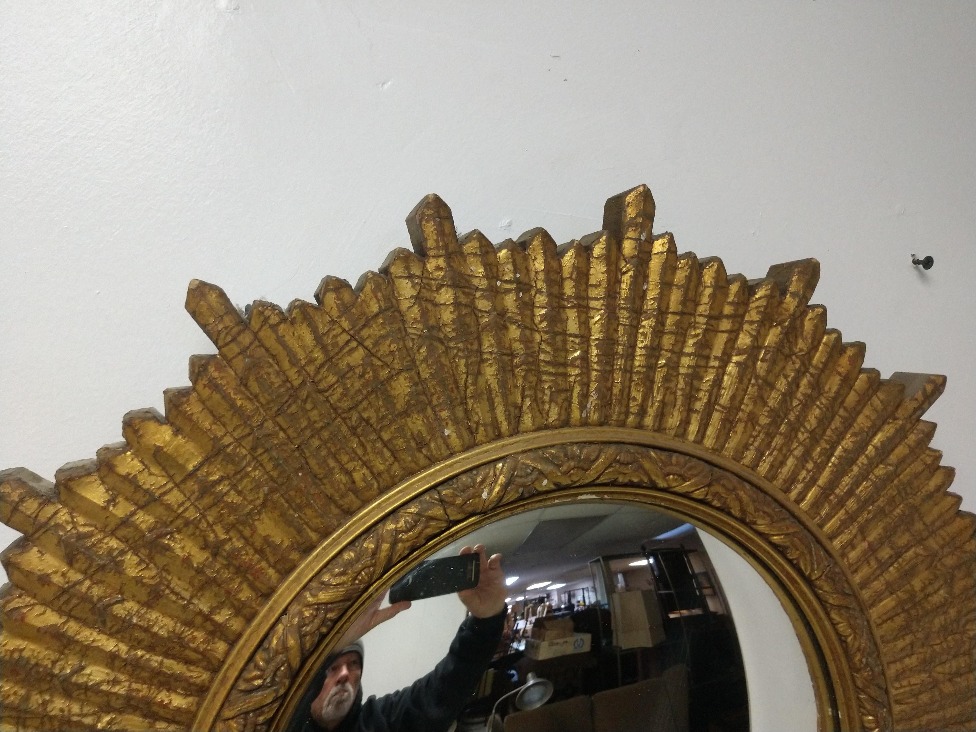 Fabulous carved wood and gilt sunburst mirror with a concave center. In excellent vintage condition, very little wear and has an great patina to the gilt. Mirror is also very clean. This item can be parcel posted, double boxed.