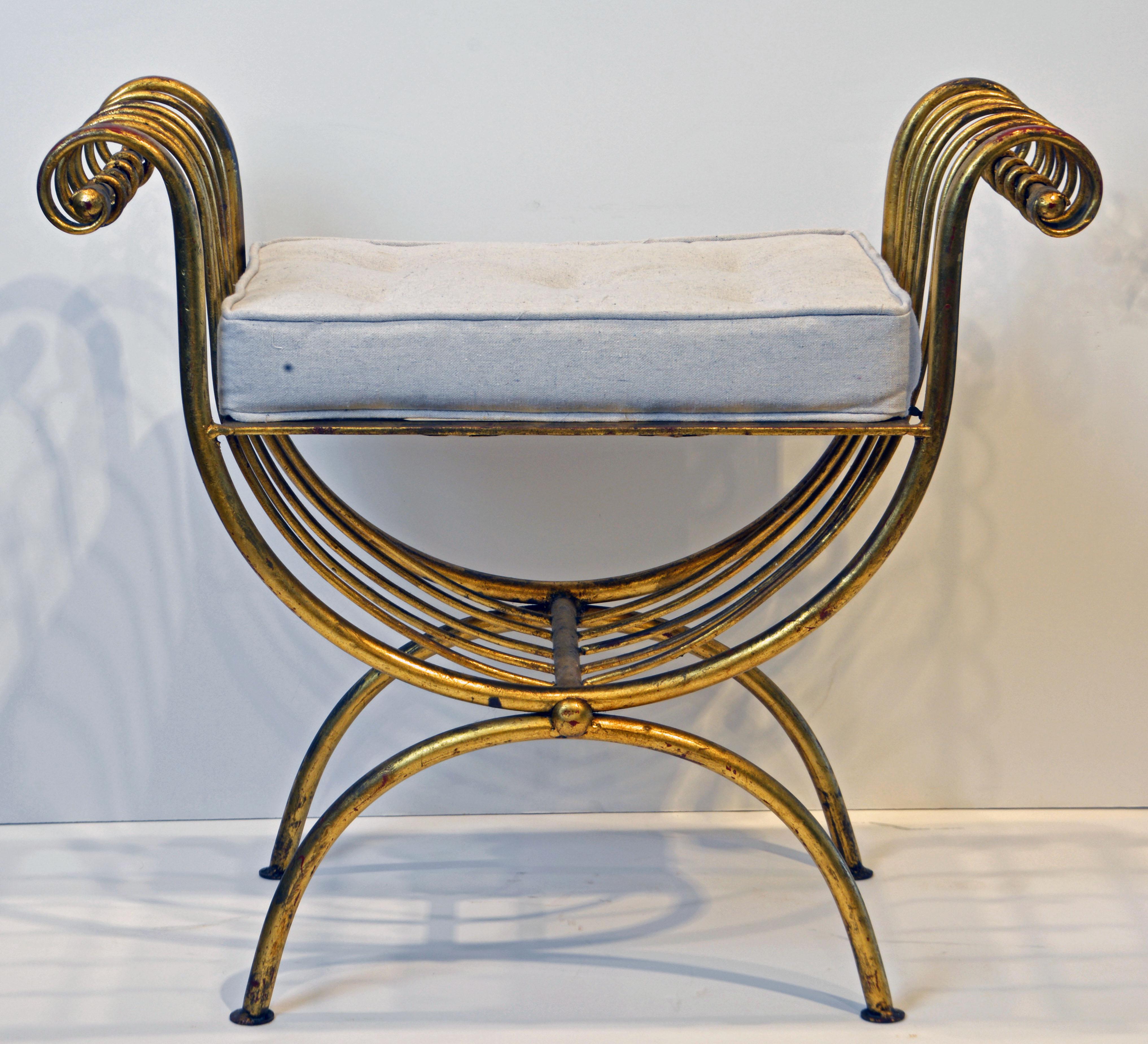 A great bench in the neoclassical Curule form. Beautiful patina to the gilt. New off white cushion.