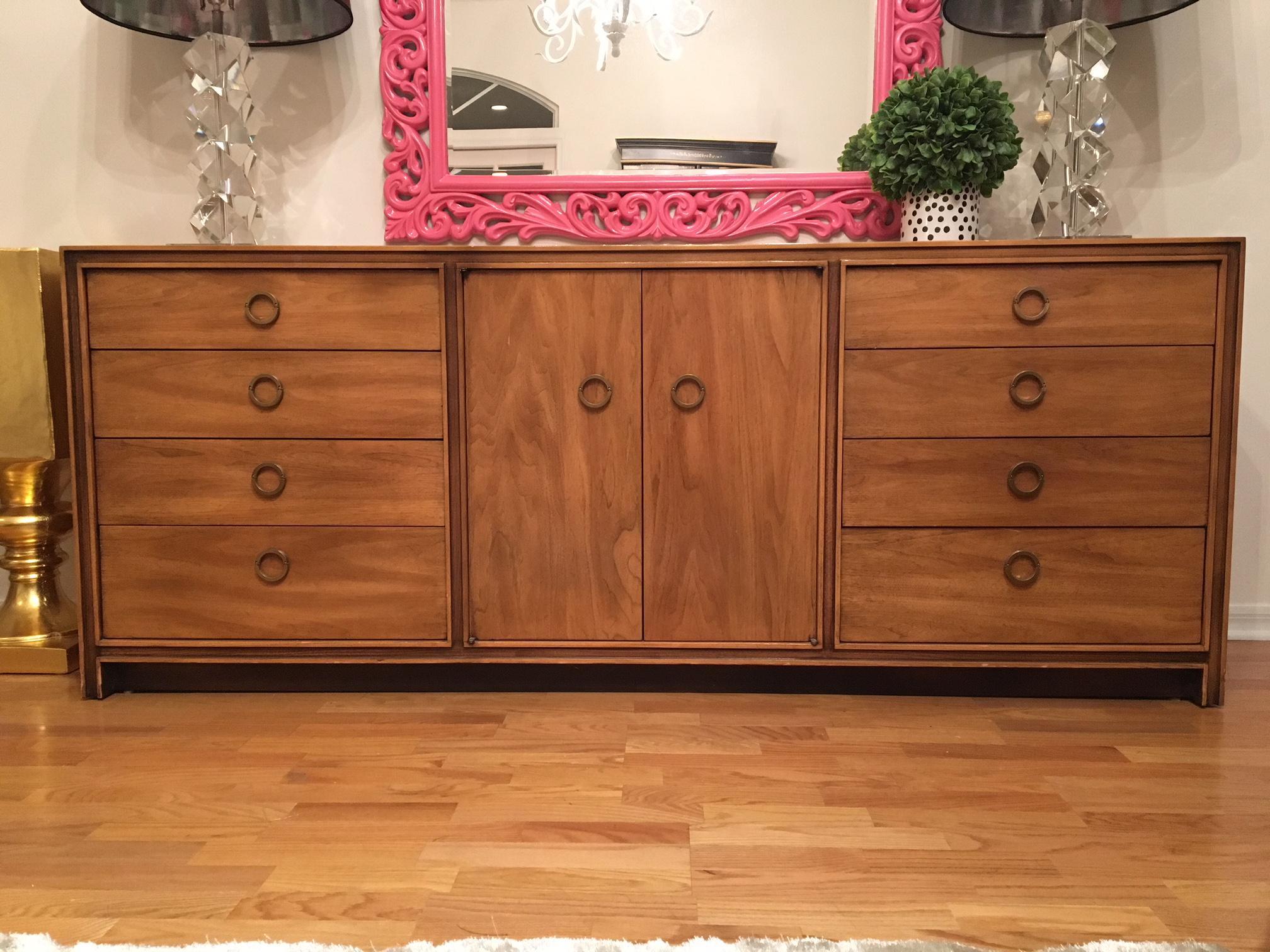 This midcentury eleven-drawer dresser by Hickory Furniture features double doors and unique brass ring hardware. Bottom half of rings are hinged to swing out as you pull. Very good vintage condition with minor signs of age appropriate wear. Some
