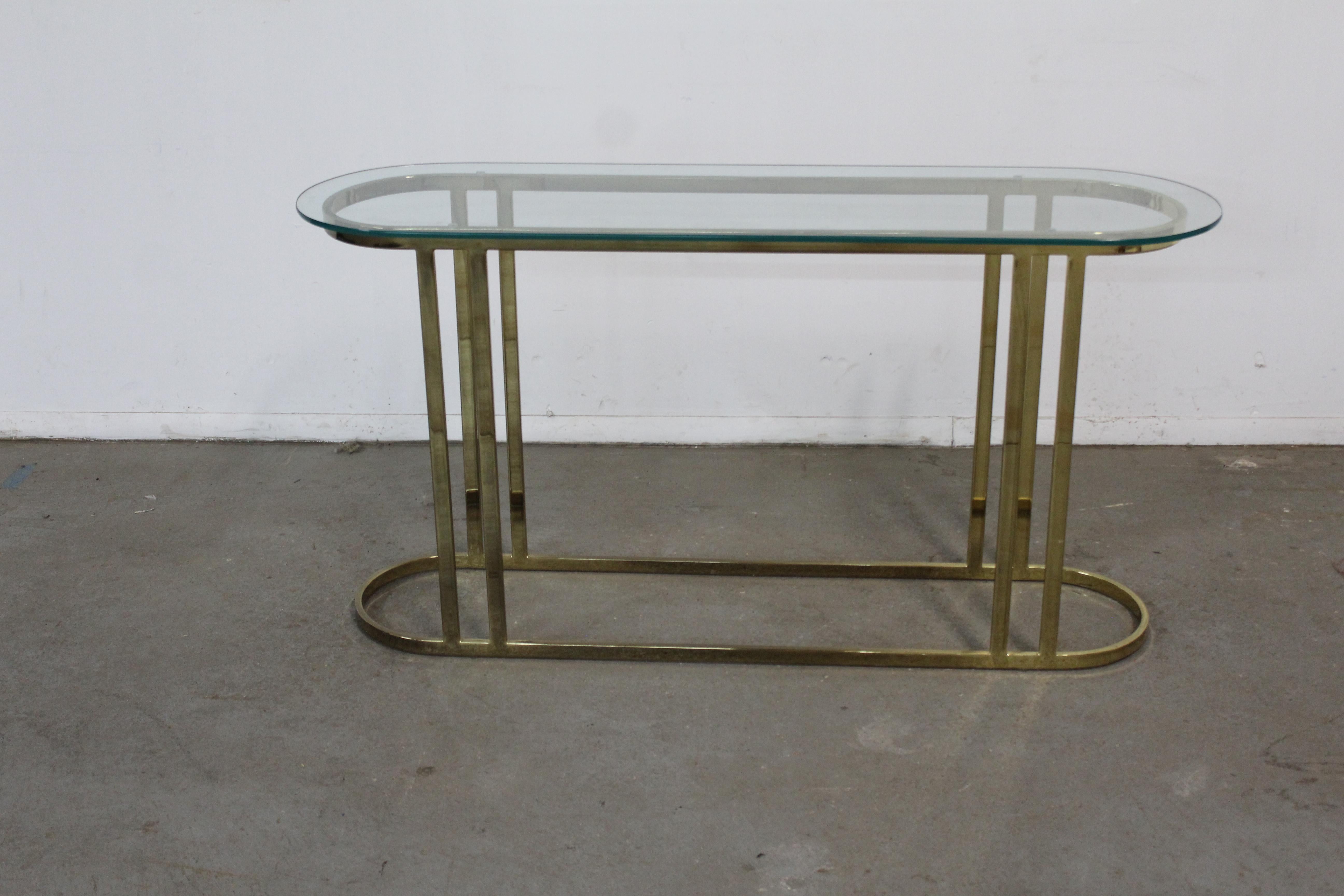 Mid Century Hollywood Regency Eliptical Brass Sofa/Hall/Console Table
 Offered is a piece of time and design a Mid Century Hollywood Regency Eliptical Brass Sofa/Hall/Console Table. The table has a nice shape. The table has a  glass top and is
