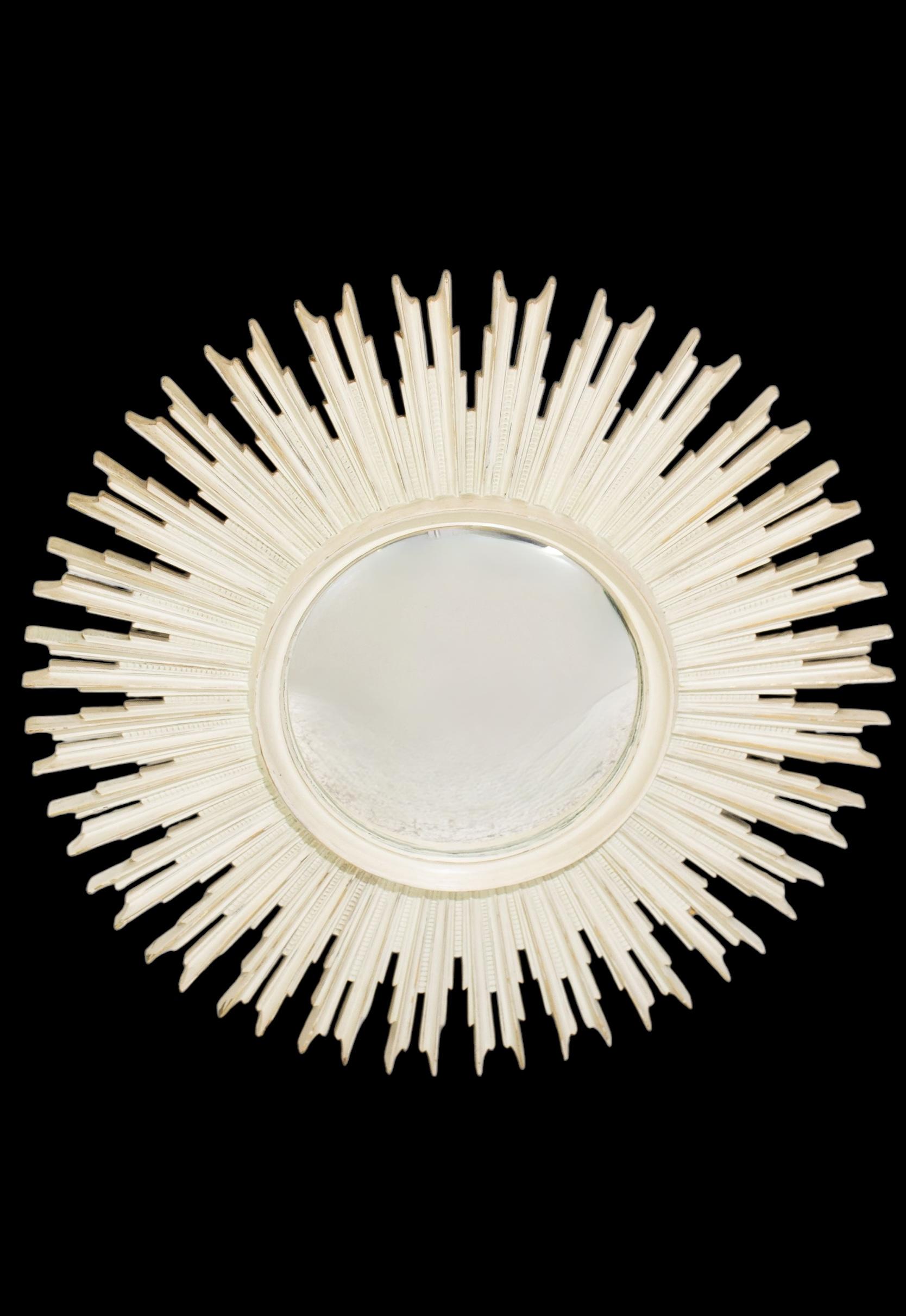 This is a mid-century Hollywood Regency era sunburst mirror that has a vintage whitewashed finish. It is carved wood with a 32 inch diameter. It is marked with the date of 1959.