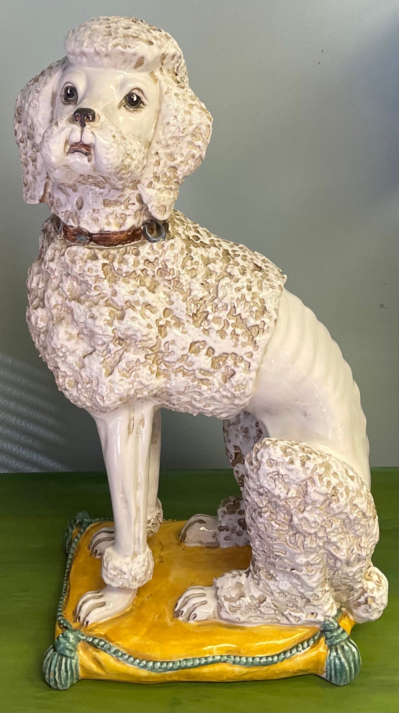 This is too fun! It is an Italian Hollywood Regency Era terracotta poodle figurine. This poodle is regally sitting on a yellow pillow. A perfect gift for someone! It is signed!