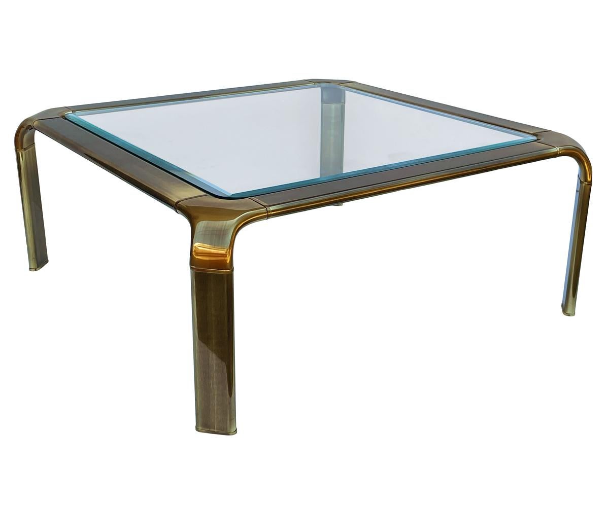A simple transitional design from a classic furniture maker, John Widdicomb. This table features patinated brass frame with inlayed clear glass. Very good condition.