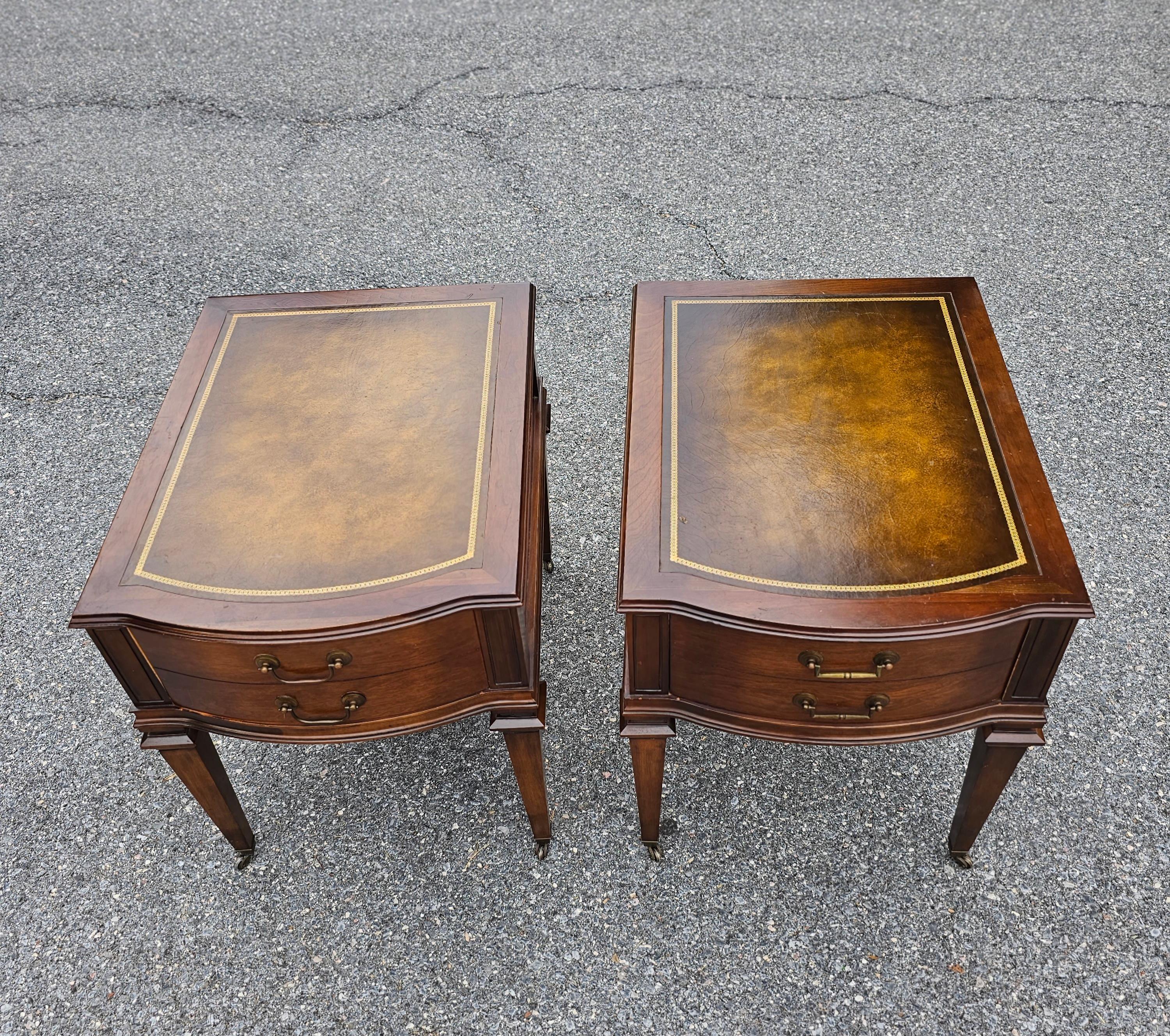 A pair of Mid-Century Hollywood Regency Mahogany and Stencil Tooled Leather Top Side Tables on original wheels, with one large single drawer. Measure 19