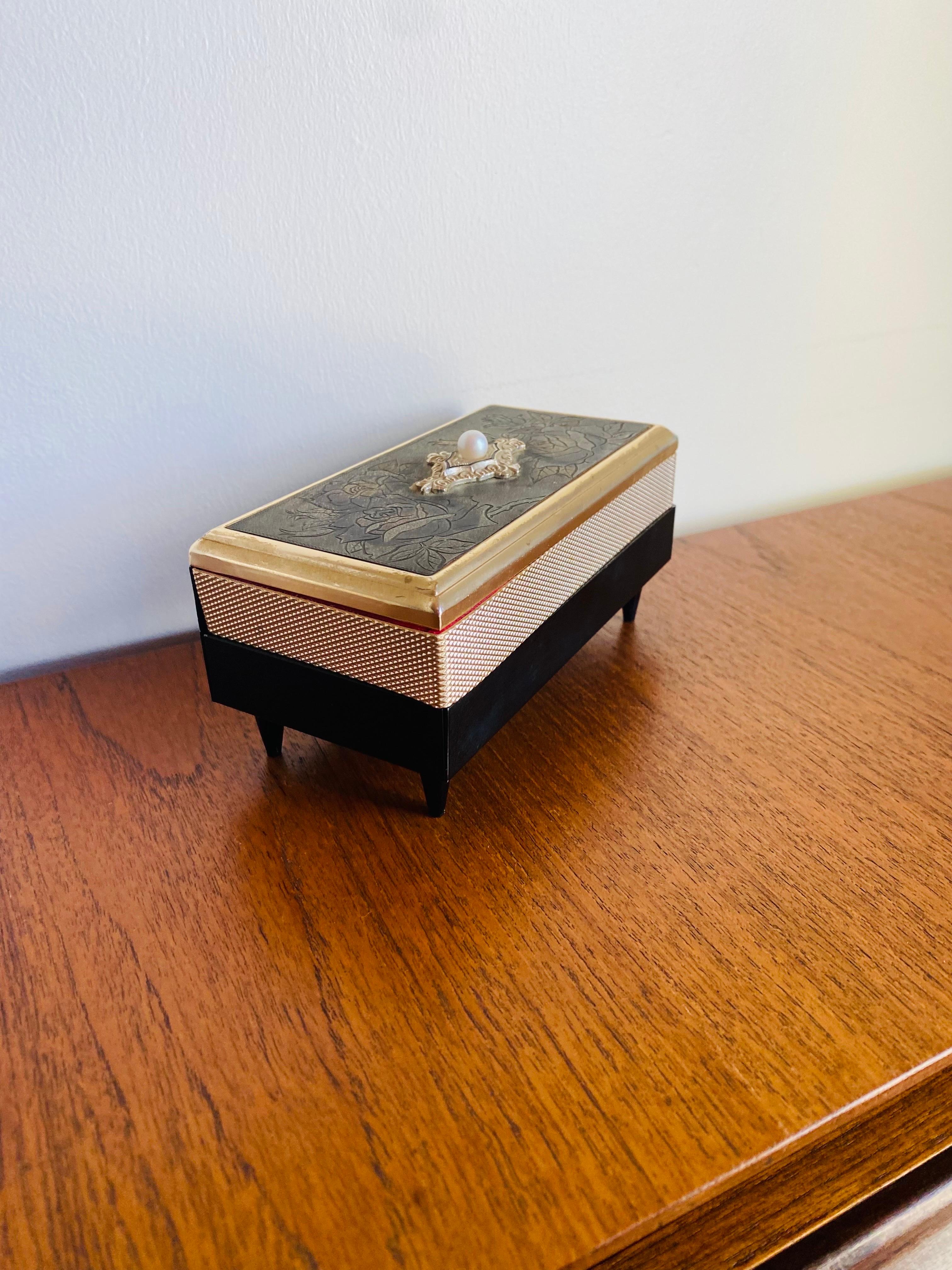 Joyero decorativo multiusos increíblemente elegante y clásico. Esta hermosa  La caja está dividida en 2 compartimentos y forrada de terciopelo rojo, e incluye un espejo de tocador.  La laca dorada de alto brillo delinea los bordes. Al levantar la