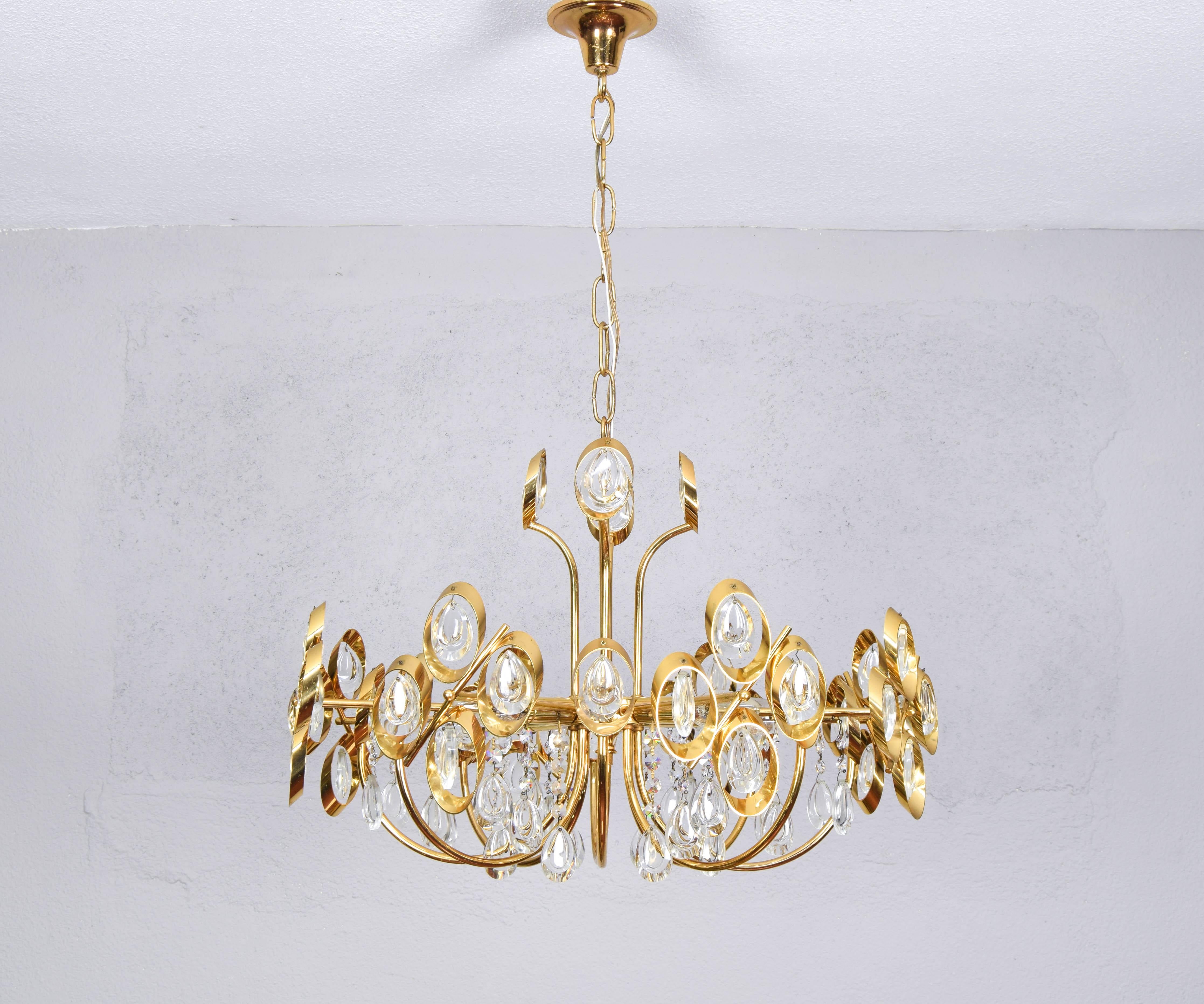 Dazzling Chandelier in golden brass and crystals, made by Palwa Germany in the 60's.
Spectacular piece made up of 16 arms, 8 of them have four crystals each framed in brass at their end and another 8 arms have a crystal at the end, also framed in