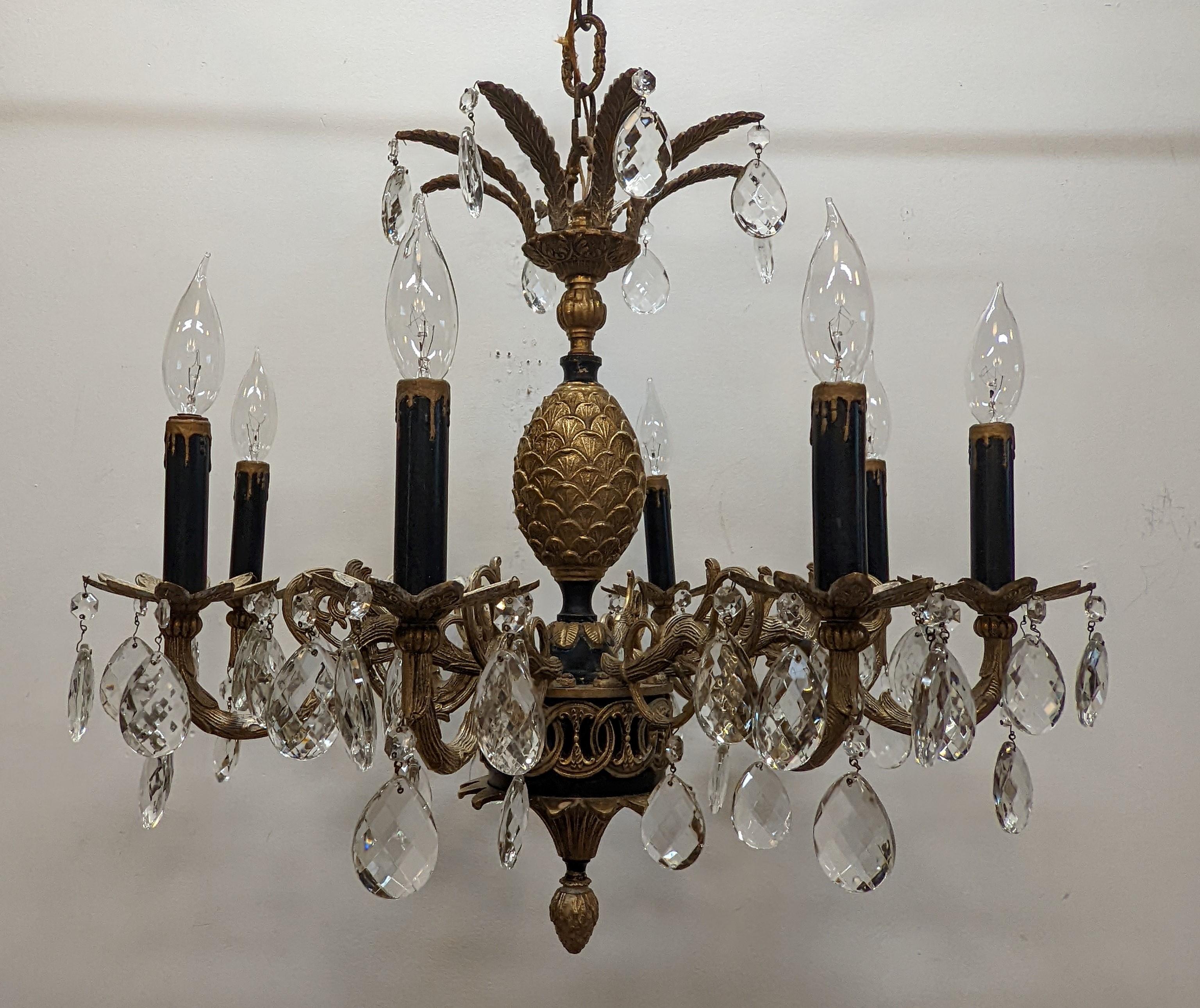 Mid-century Regency Pineapple chandelier of high quality. Hollywood Regency chandelier stylized pineapple design of detailed solid bronze and brass. Eight branches with florets housing faux candle canaster lights surrounding a highly detailed