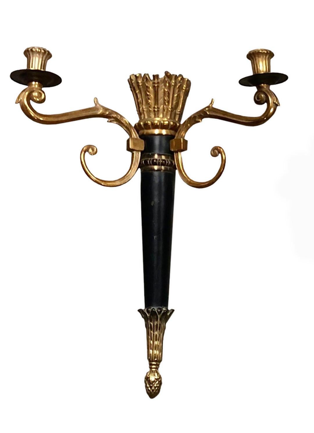 A pair of bronze doré and black two candle Hollywood Regency wall sconces with great patina. The center has arrows and a quiver. Circa late 1940 to early 1950s. 