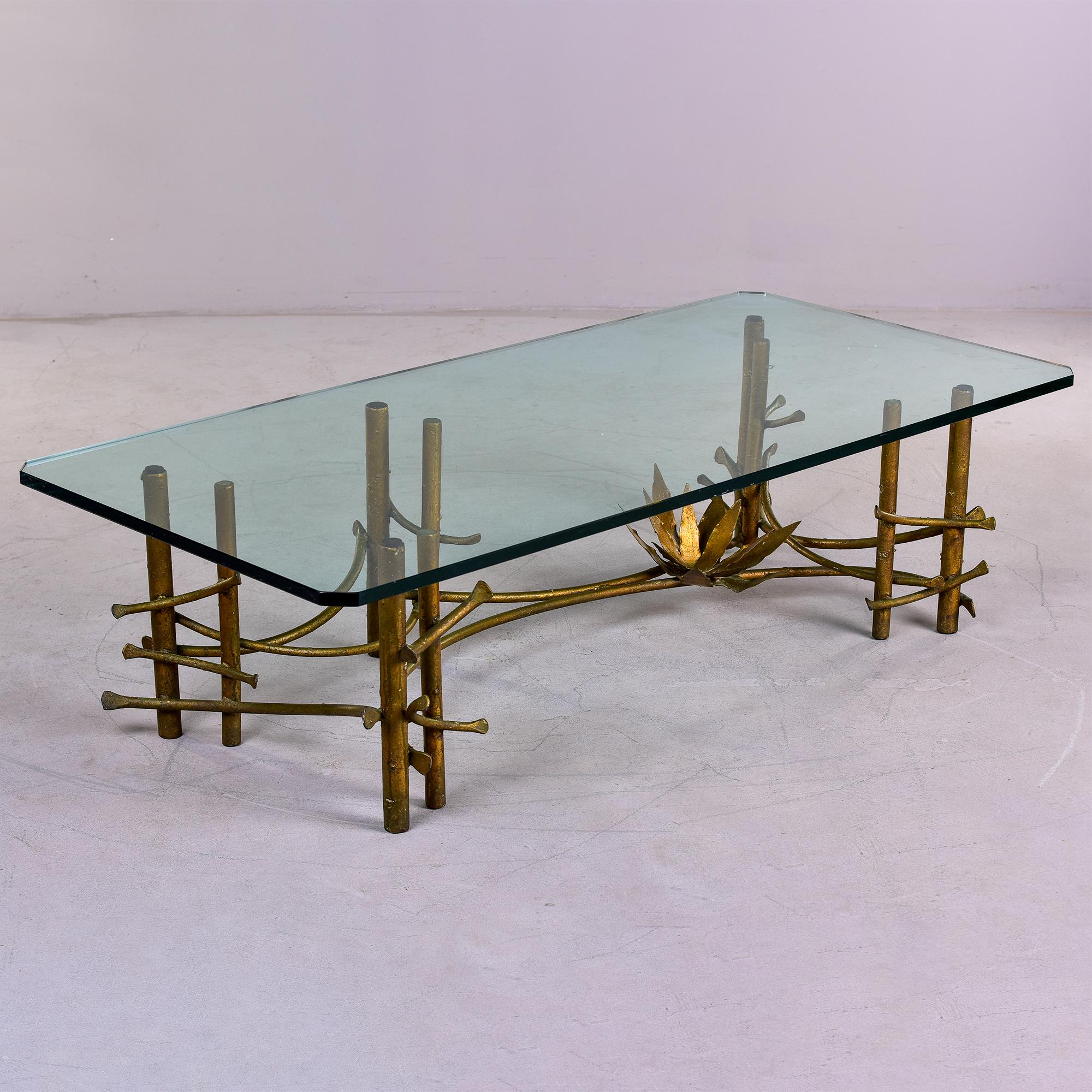 Circa 1970s large glass and gilt bronze coffee table designed by Silas Seandel. Asian-influenced with lotus blossom - classic Hollywood Regency style with honest wear and patina. Original thick, heavy glass top has a small scratched area - see