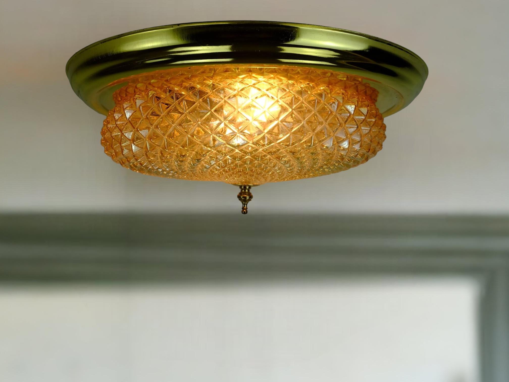 Elegant ceiling lamp made in the 1970s. Without manufacturer identification, probably Glashütte Limburg or Schroeder-Leuchten. The base is made of white painted metal, the frame is made of brass. The shade is made of glass with a light amber tone