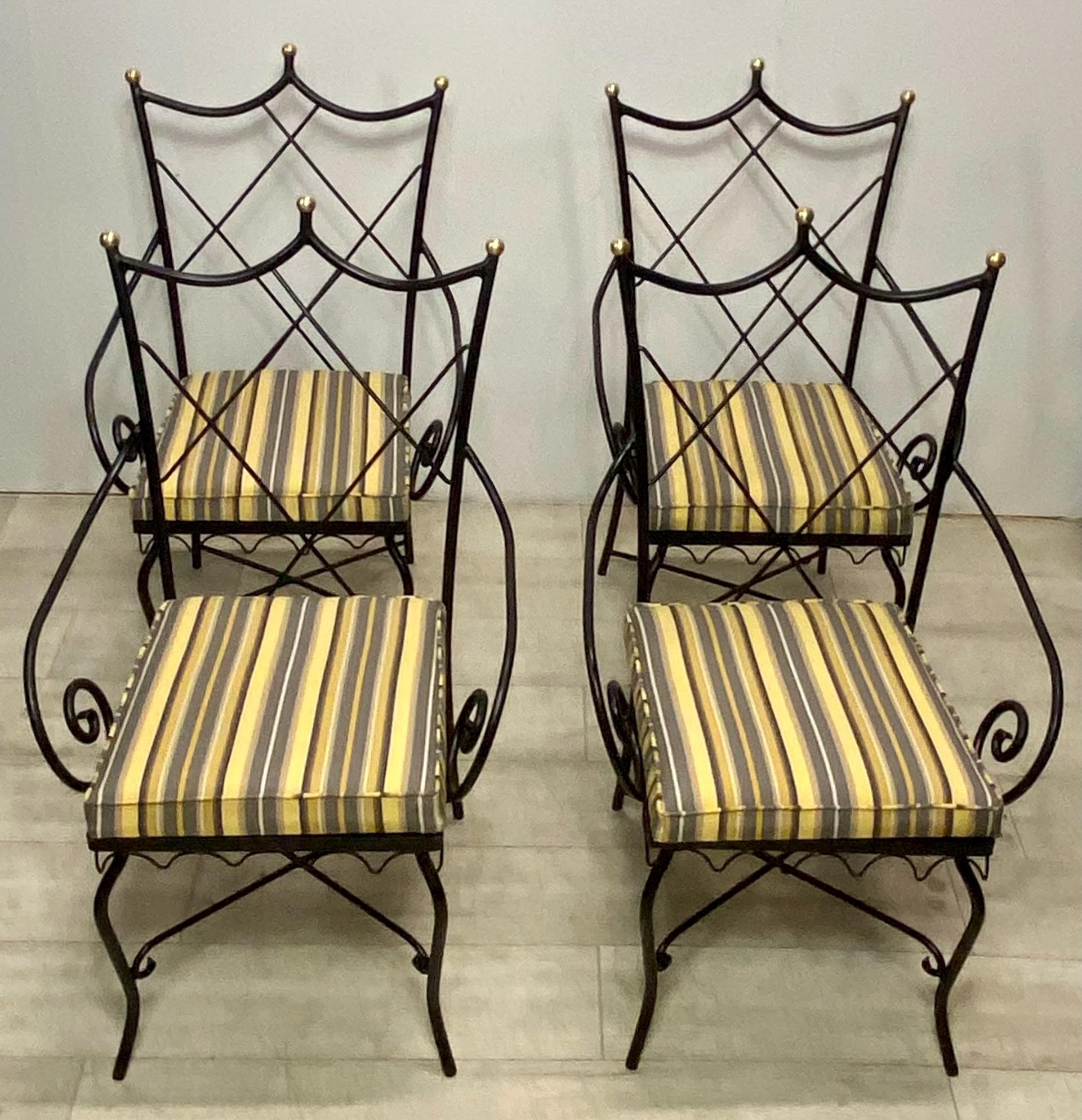 A set of 4 Hollywood Regency style patio chairs.
Freshly painted black iron with polished brass finial detail and new outdoor water repellant upholstered cushions.
Set consists of two armchairs and two side chairs.
Mid Century, 1930-1960.
In
