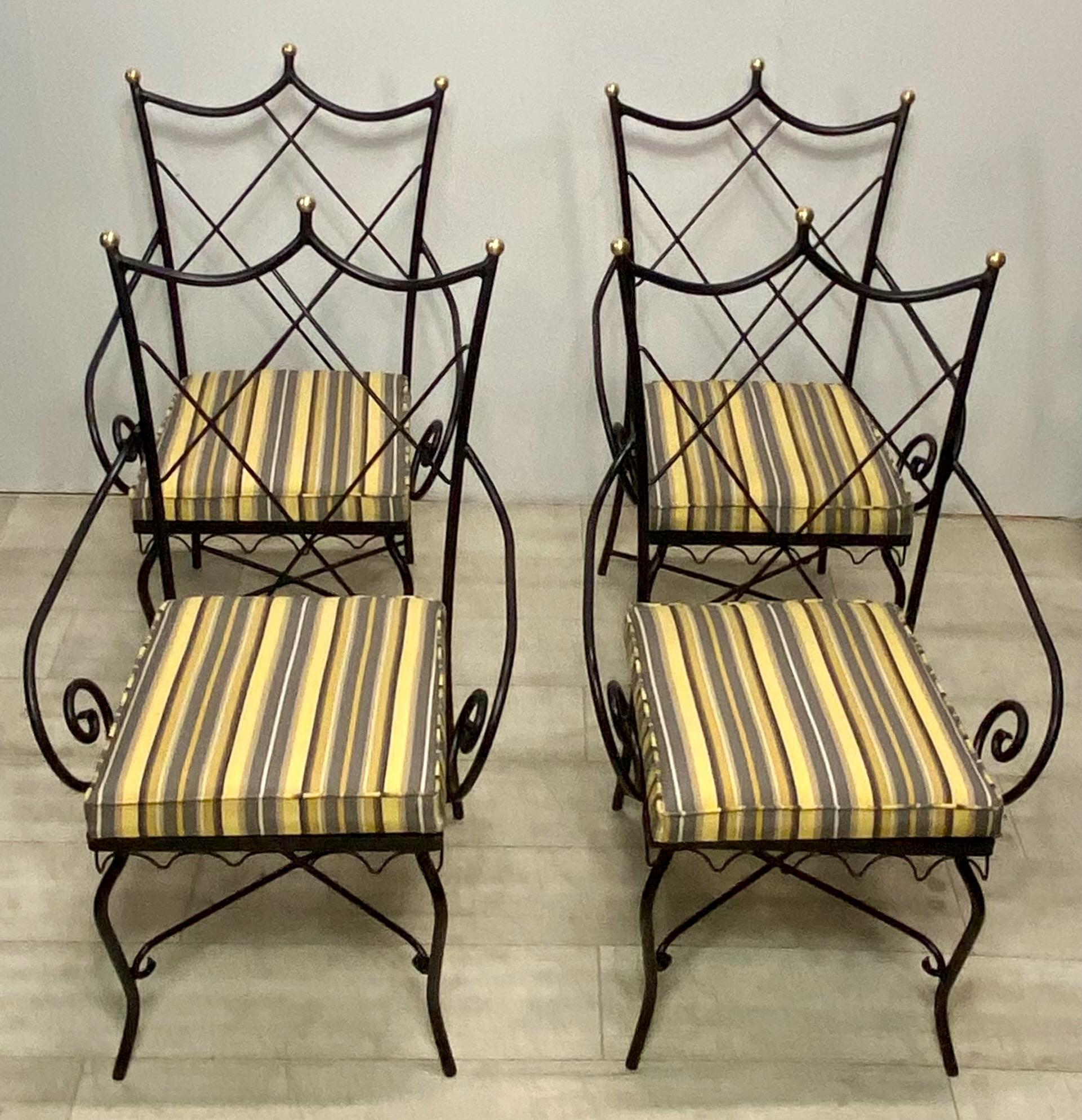 Un ensemble de 4 chaises de patio de style Hollywood Regency.
Fer noir fraîchement peint avec des détails de finitions en laiton poli et de nouveaux coussins rembourrés hydrofuges pour l'extérieur.
L'ensemble comprend deux fauteuils et deux