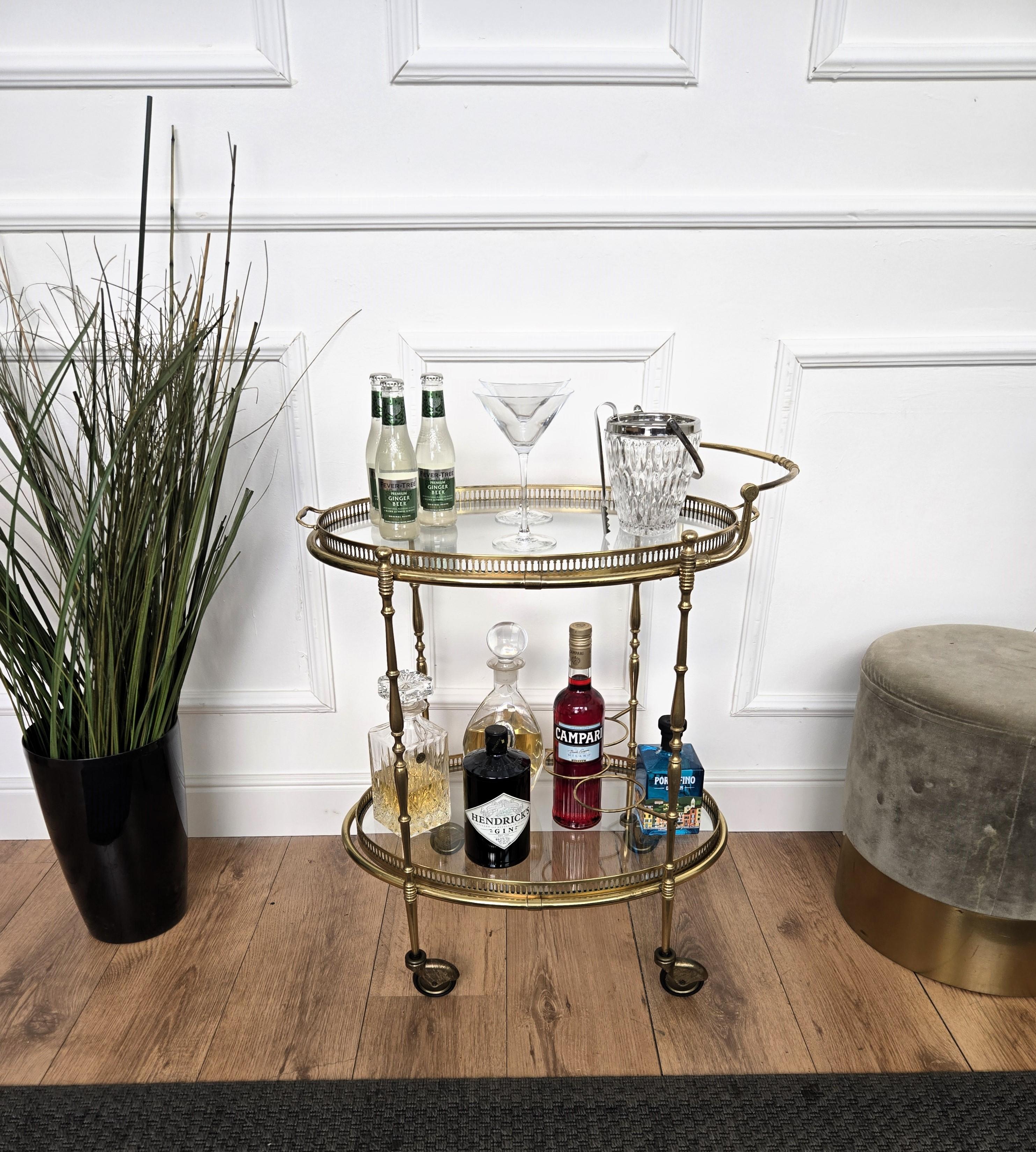 Magnifique et élégant chariot de bar ovale à deux niveaux en laiton et verre vintage italien des années 1970 avec de superbes détails décoratifs et un plateau amovible. Une pièce exceptionnelle qui ajoute parfaitement à la décoration de chaque