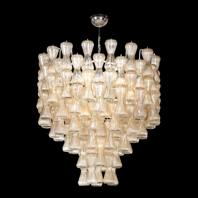 This rare and stunning Mid Century Modern chandelier was realized in Murano, Italy- the island off the coast of Venice renowned for centuries for its superlative glass production- by the legendary atelier of Seguso. The fixture offers a cylindrical