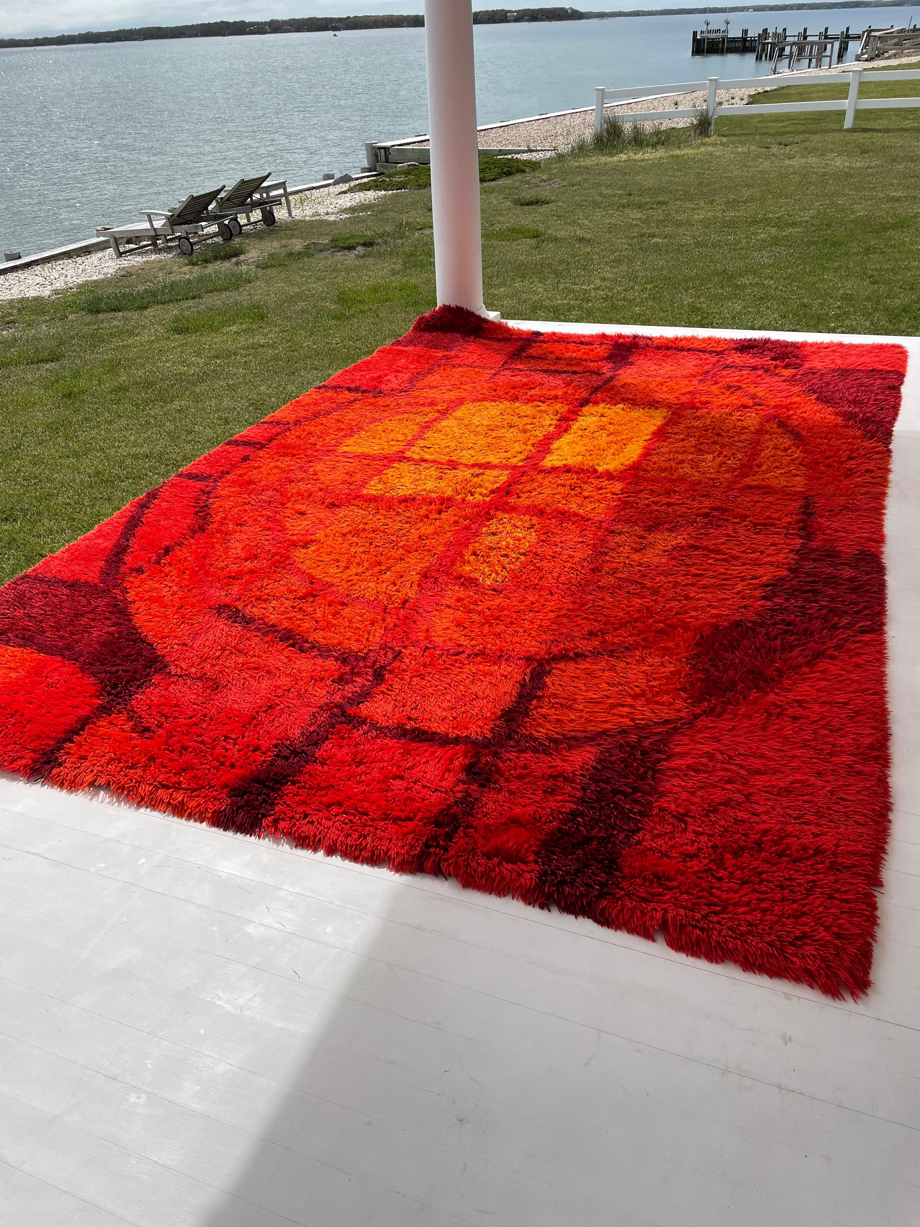 Un produit étonnant et rare. Difficile de trouver ces tapis scandinaves Rya vintage dans cette grande taille en si bon état . Ce tapis Rya vibrant et pelucheux présente des oranges, des rouges et des jaunes dans un motif géométrique abstrait. Une