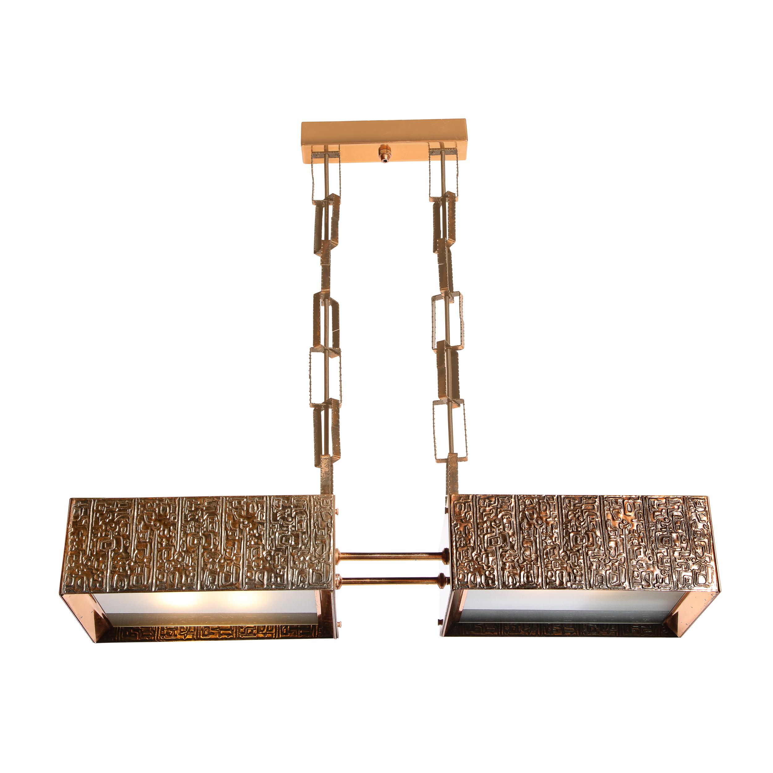 This stunning and exceedingly rare brutalist chandelier was realized in Hungary circa 1970. It features two volumetric rectangular forms adjoined by cylindrical supports all in copper. The sides of the chandelier are inscribed with brutalist glyphic