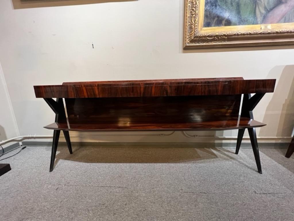 Beautiful and elegant console is made out of walnut wood with spectacular wood grain. Console has 2 spacious drawers and an extra shelf on the bottom. Console is elevated by 4 thin legs that are made out of ebonized walnut wood, creating “X”