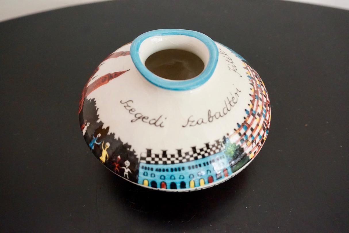 Midcentury Hungarian hand painted ceramic vase, 1960s

This commemorative, hand painted small vase was made in the honour of the iconic Szeged Open Air Festival. Szeged is a major Hungarian town close to its southern borders. In the first half of