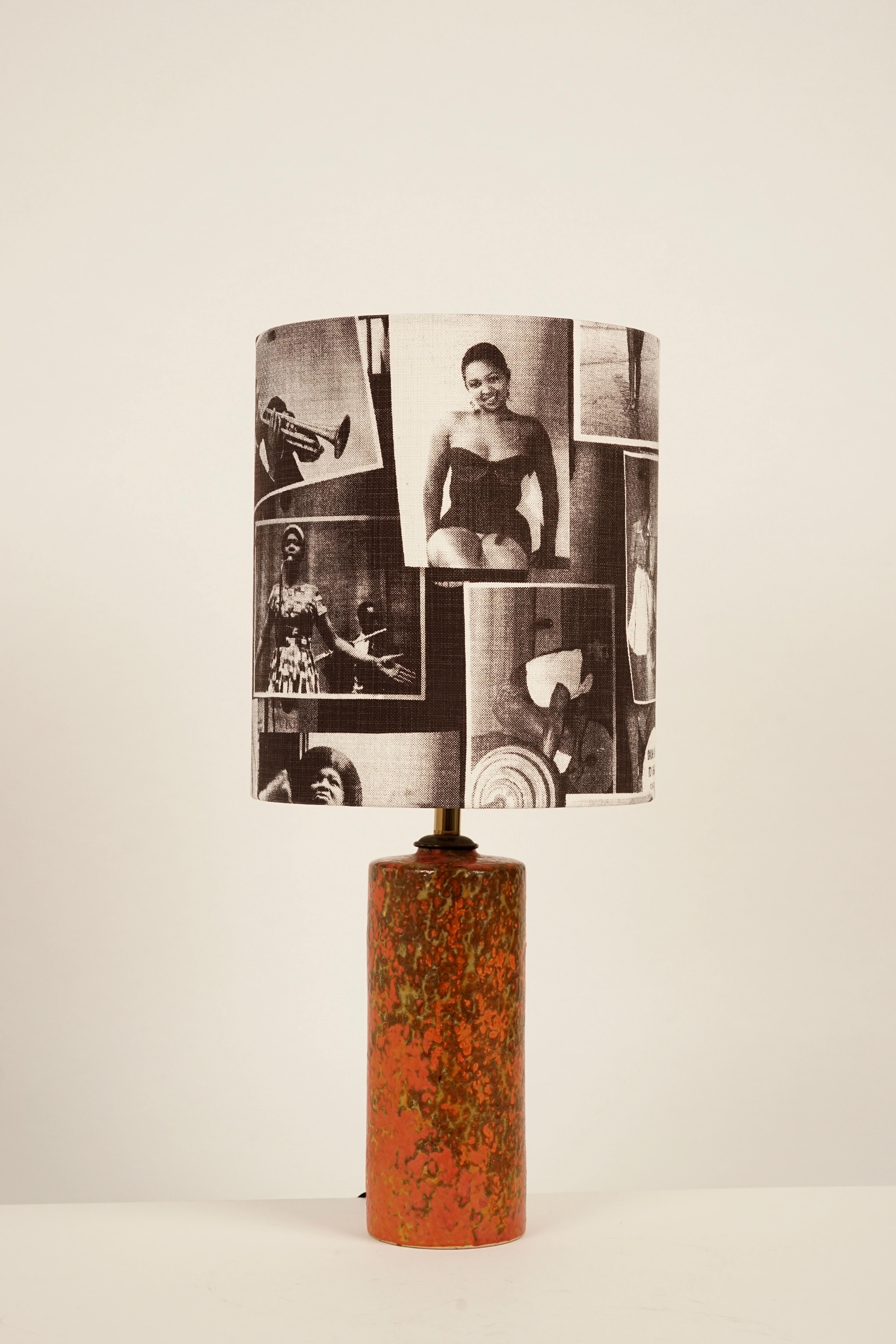 La base de la lampe provient du studio de céramique hongrois, époque 1950. La céramique formée à la main est vitrifiée en orange.
L'abat-jour a été récupéré dans un tissu en coton avec des motifs du magazine Drum.