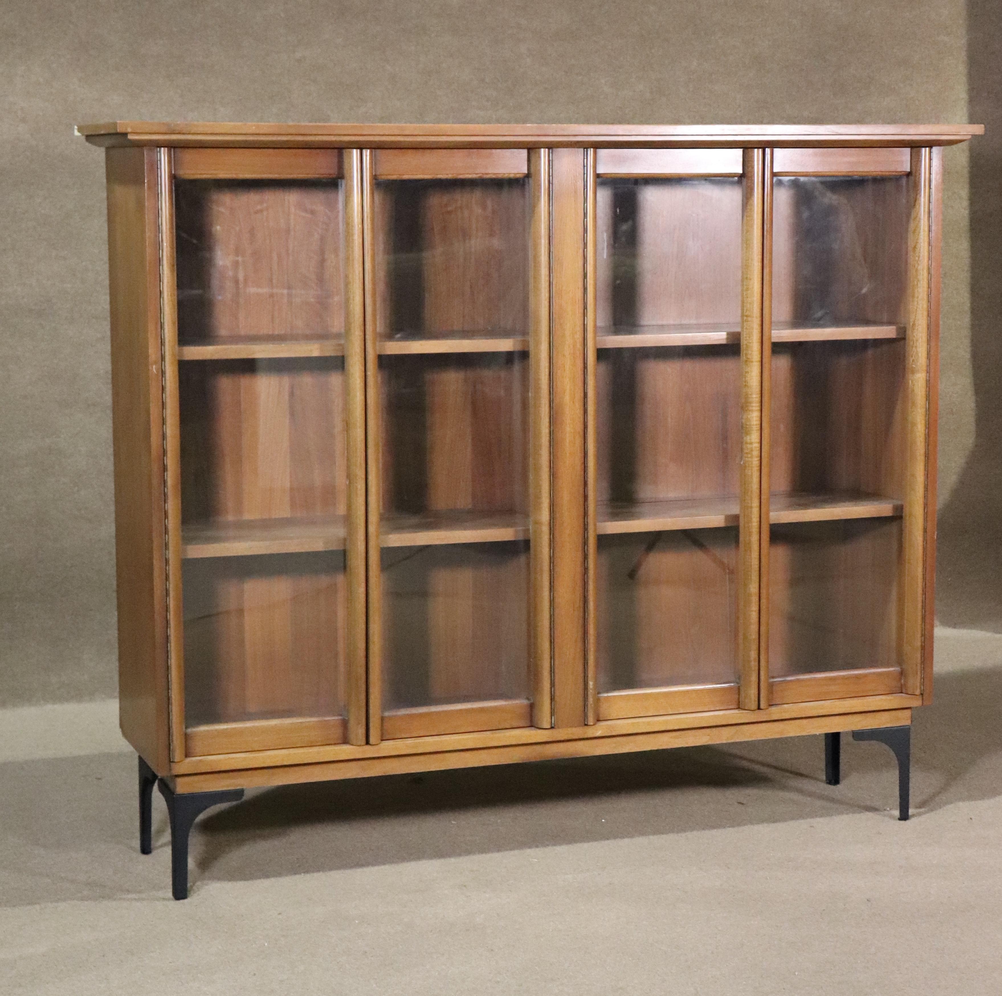 Standing mid-century modern cabinet with shelving. Four glass doors enclose the display cabinet.
Please confirm location NY or NJ