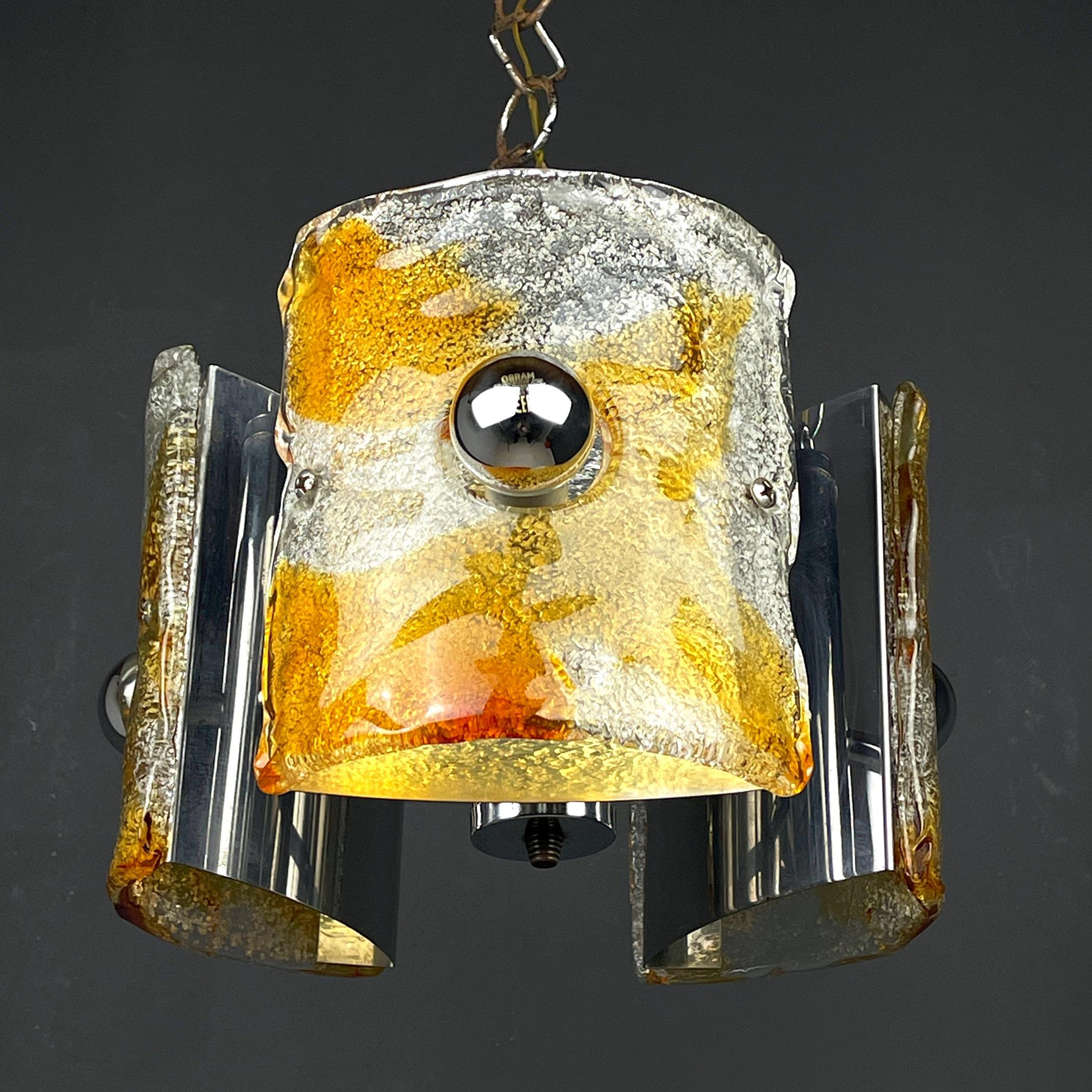 Midcentury ice Murano glass chandelier by AV Mazzega was made in Italy in the 1970s. Although the lamp is not signed, we are sure of the heritage: the form and the used materials, from blown Murano glass and chrome, are typical for Mazzega. AV