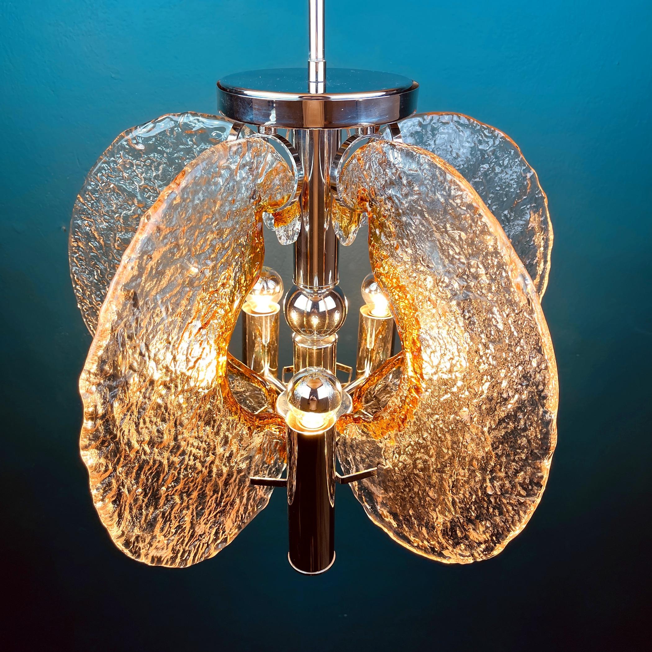 Rare gorgeous ice Murano glass chandelier by Mazzega. Made in Italy in the 1970s.
The ice glass effect and shades of gold, amber create a unique atmosphere in the home. It will become a source of pride and, of course, this chandelier will attract