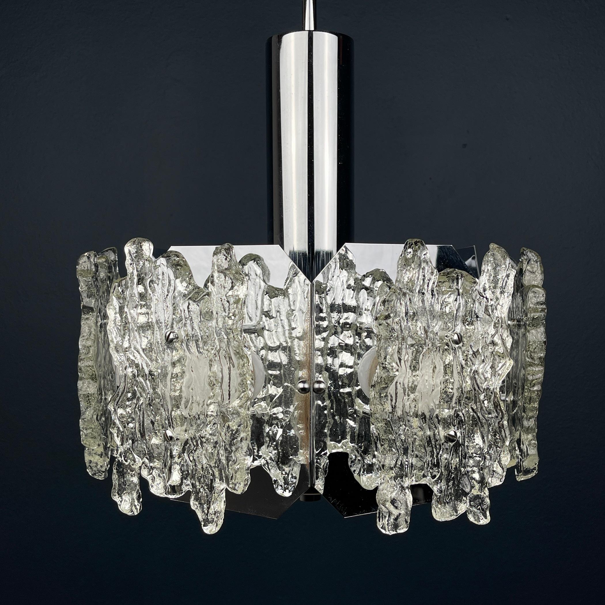 This vintage ice Murano glass chandelier is a mid-century masterpiece made in Italy in the 1970s. Crafted from blown-thick Murano glass, it showcases exceptional craftsmanship and design. The chandelier boasts a striking and elegant presence that